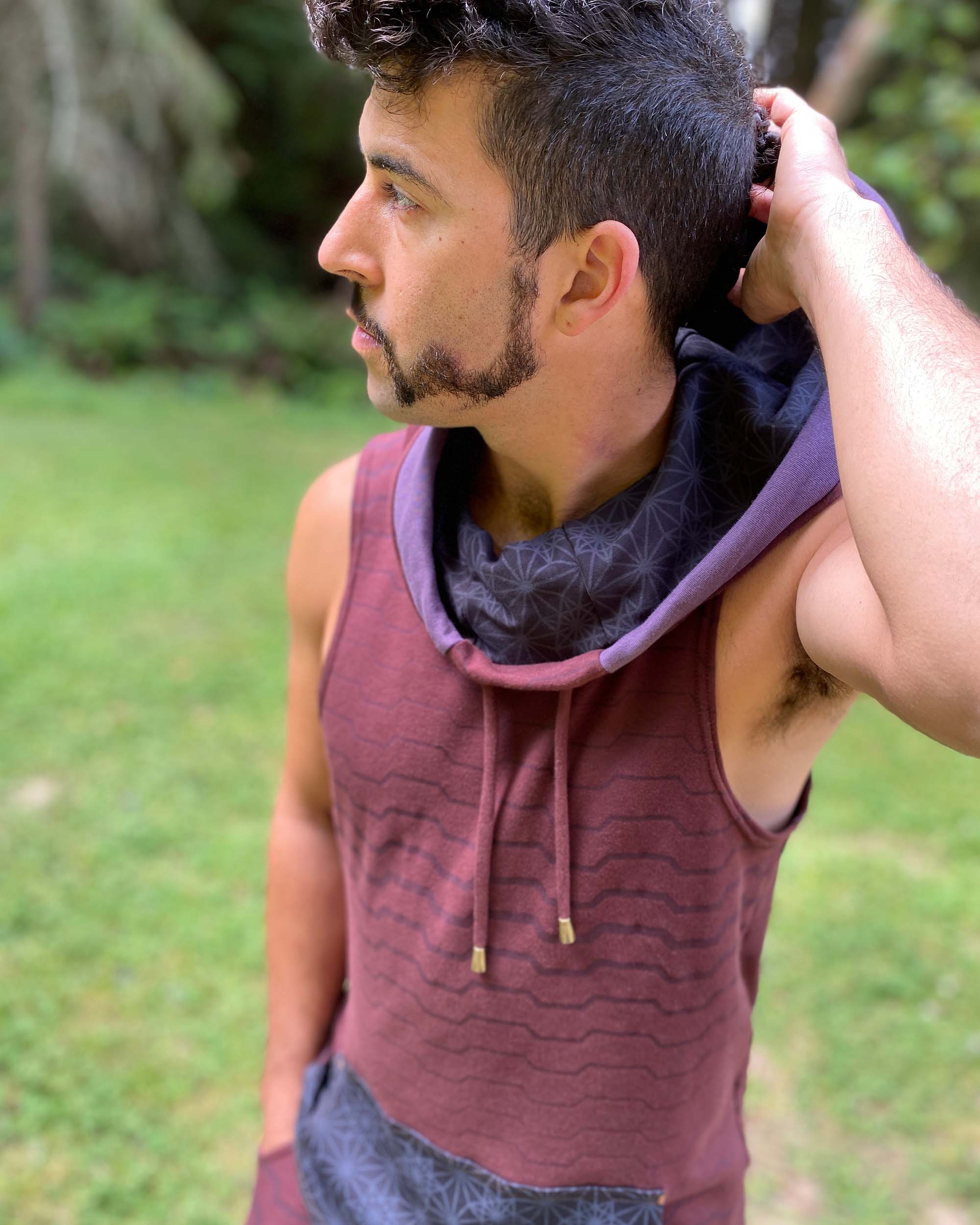 Organic cotton hooded tank top, reddish brown fabric with geometric print, front close up view of fabric.