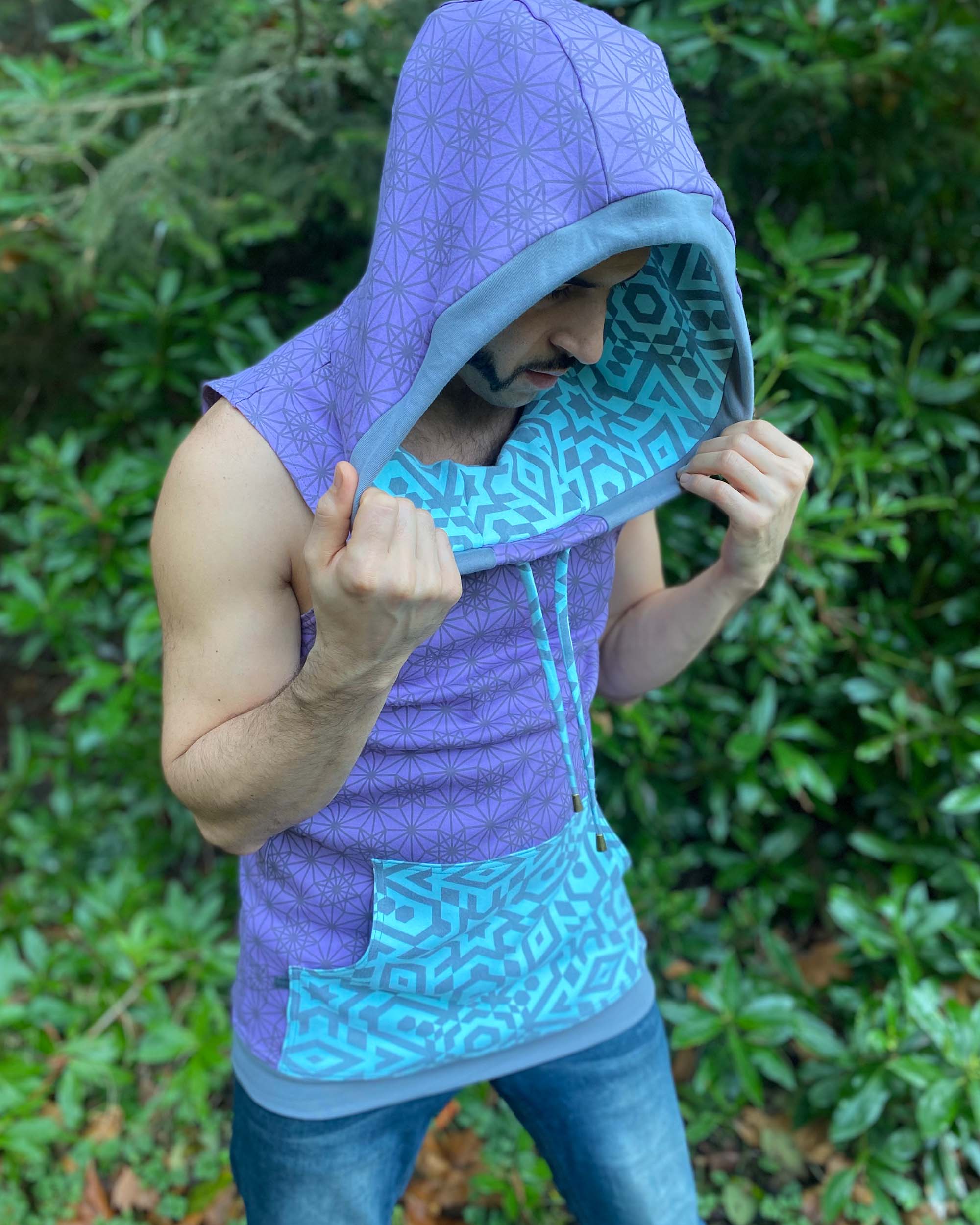 Organic cotton hooded tank top, lavender and mint fabric with geometric print, male model with hood up.