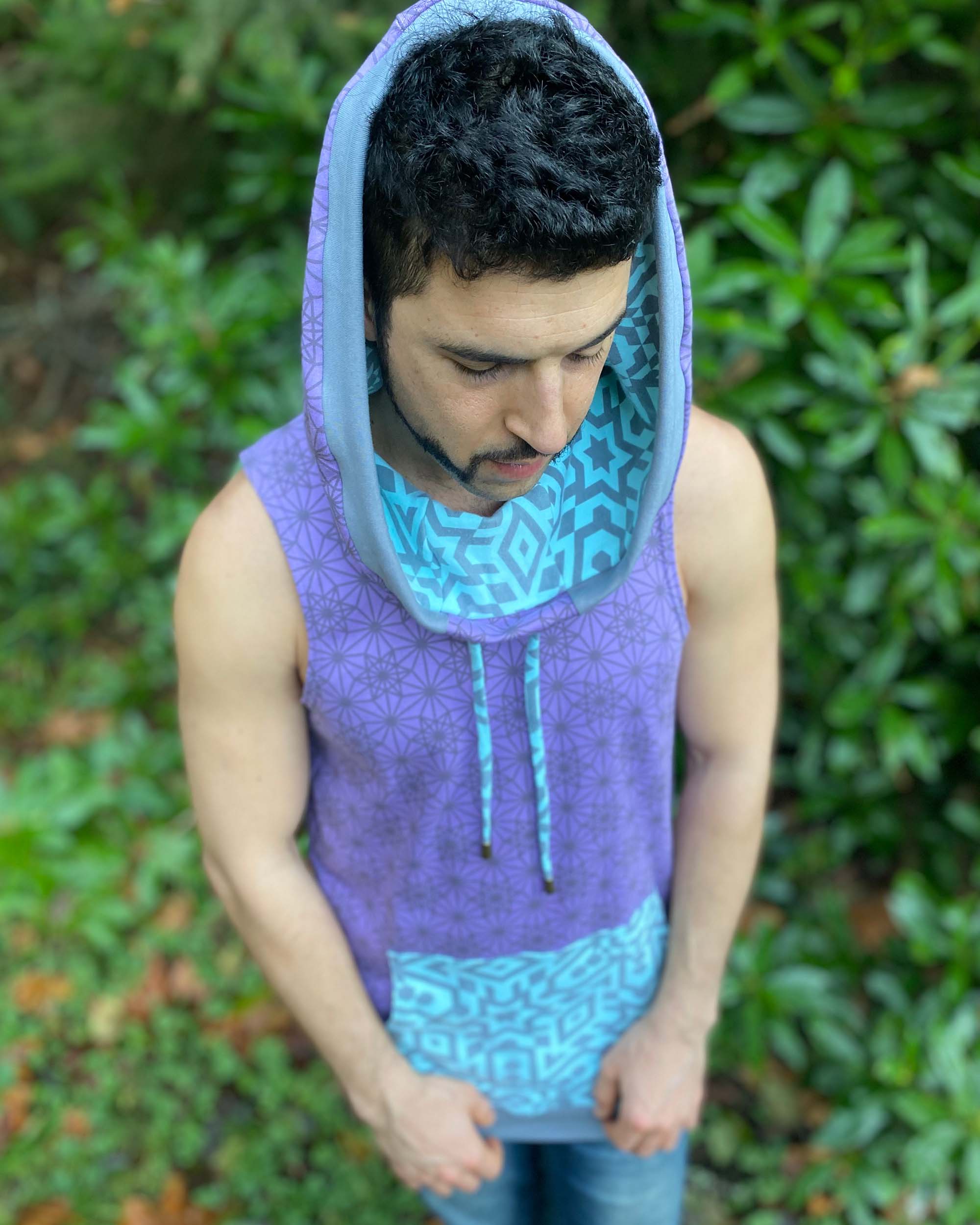 Organic cotton hooded tank top, lavender and mint fabric with geo print, top view of model with hood up.