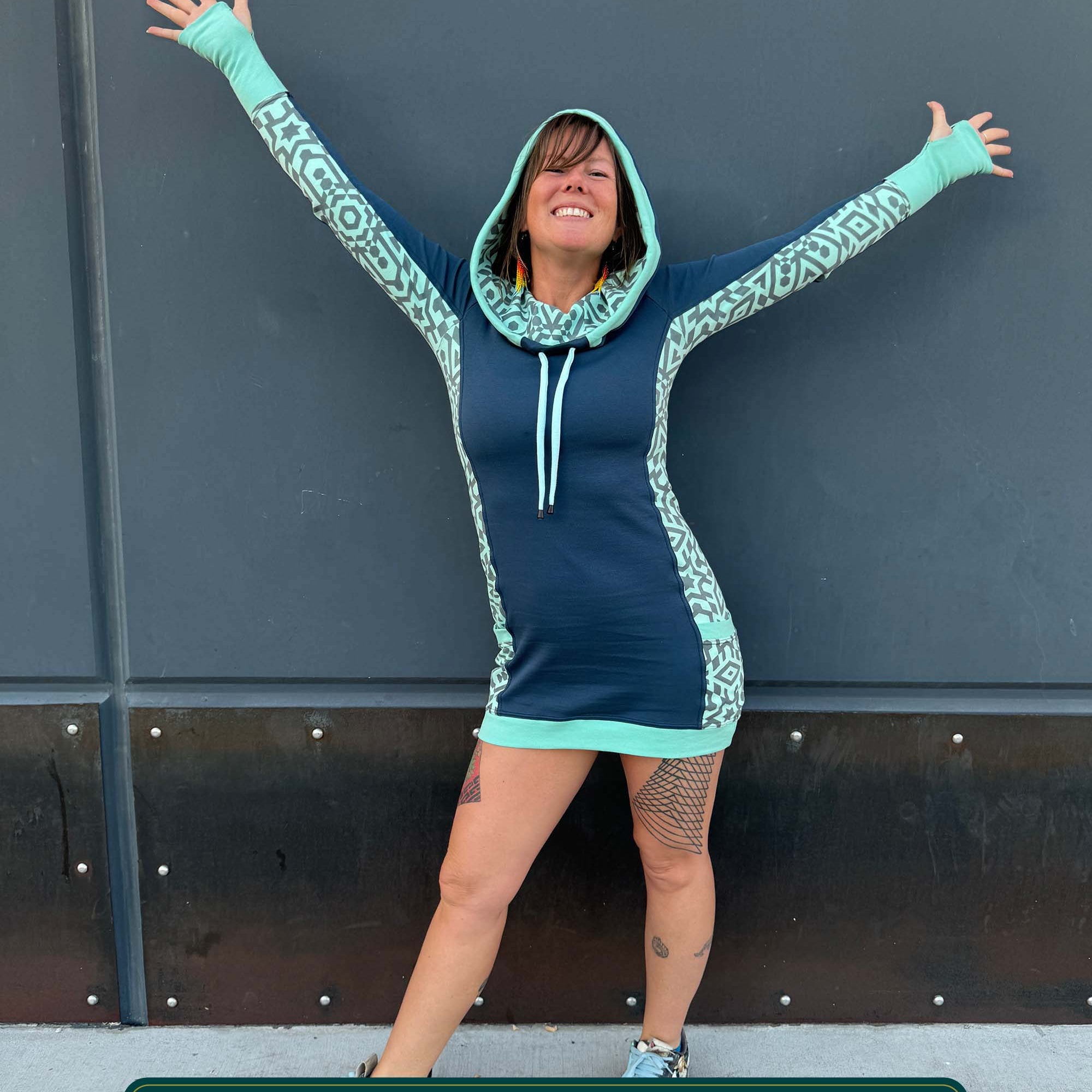 Organic cotton hooded tunic dress, blue with geometric mint fabric accents, front view on model.