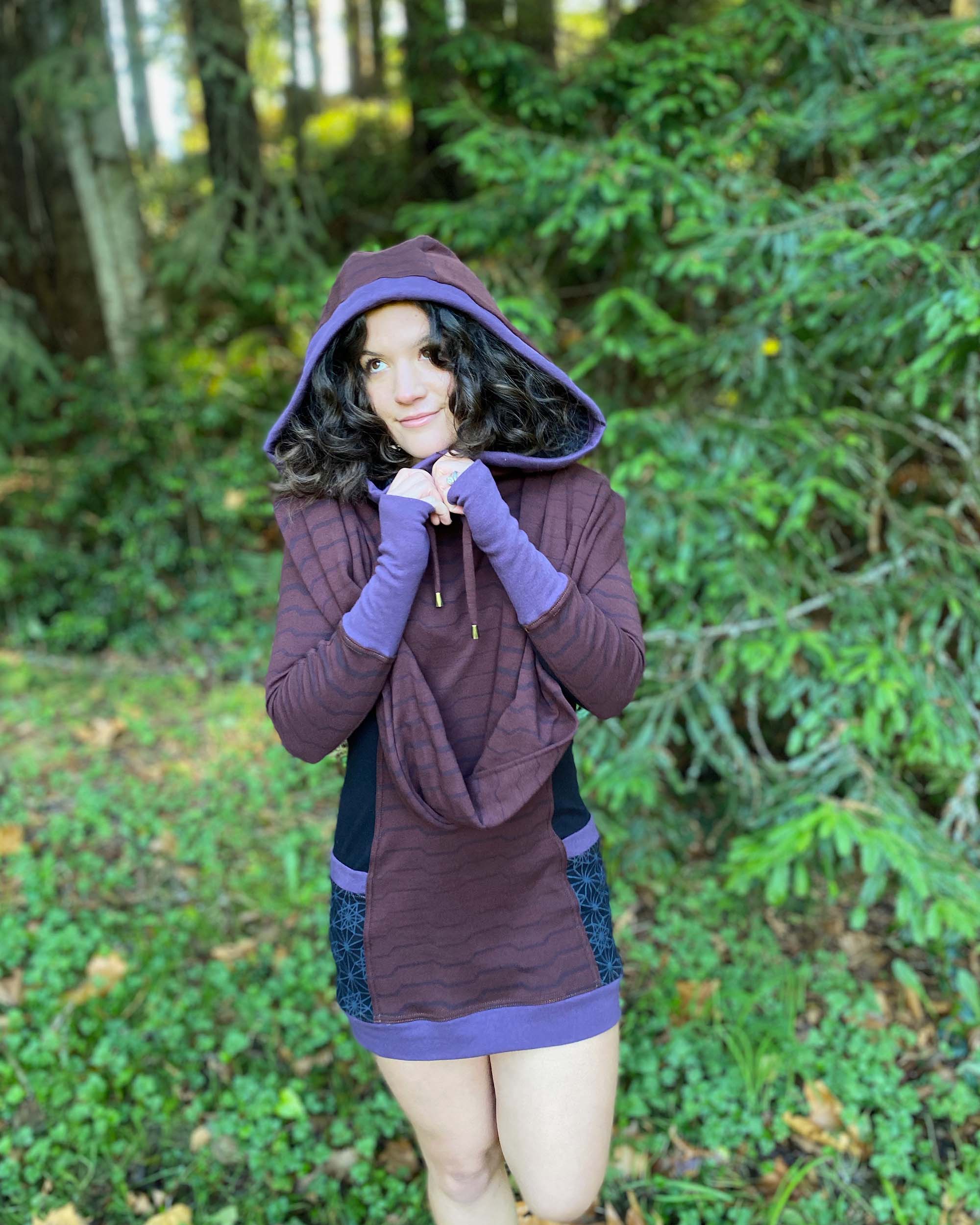 Organic cotton hooded tunic dress, reddish brown with geometric print, front view on model in nature.