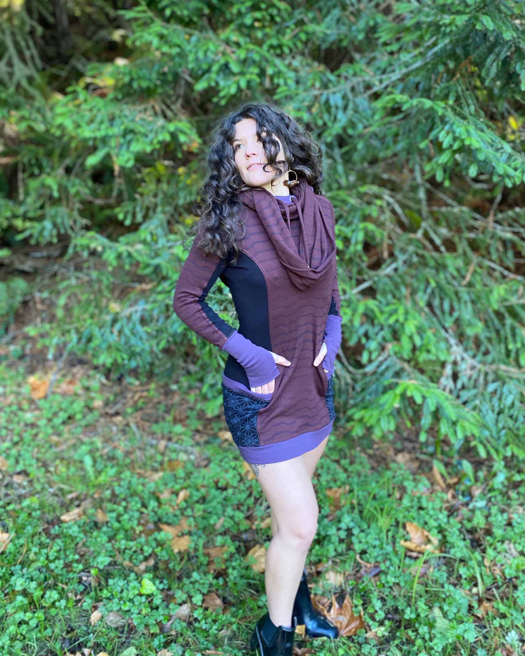 Organic cotton hooded tunic dress, reddish brown with geometric black fabric accents, right side view on model.