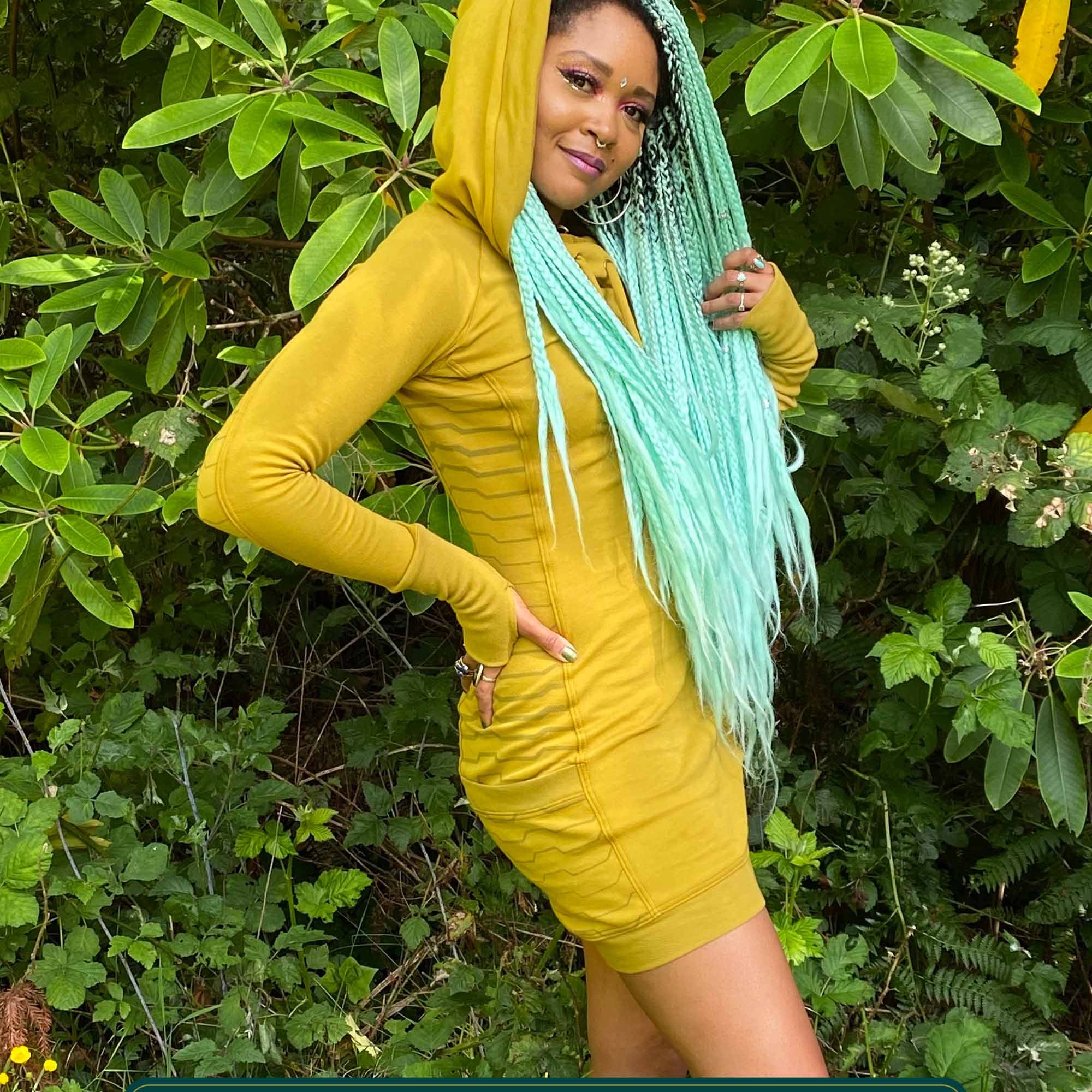 Organic cotton hooded tunic dress, yellow fabric with geometric print, right side view on model.