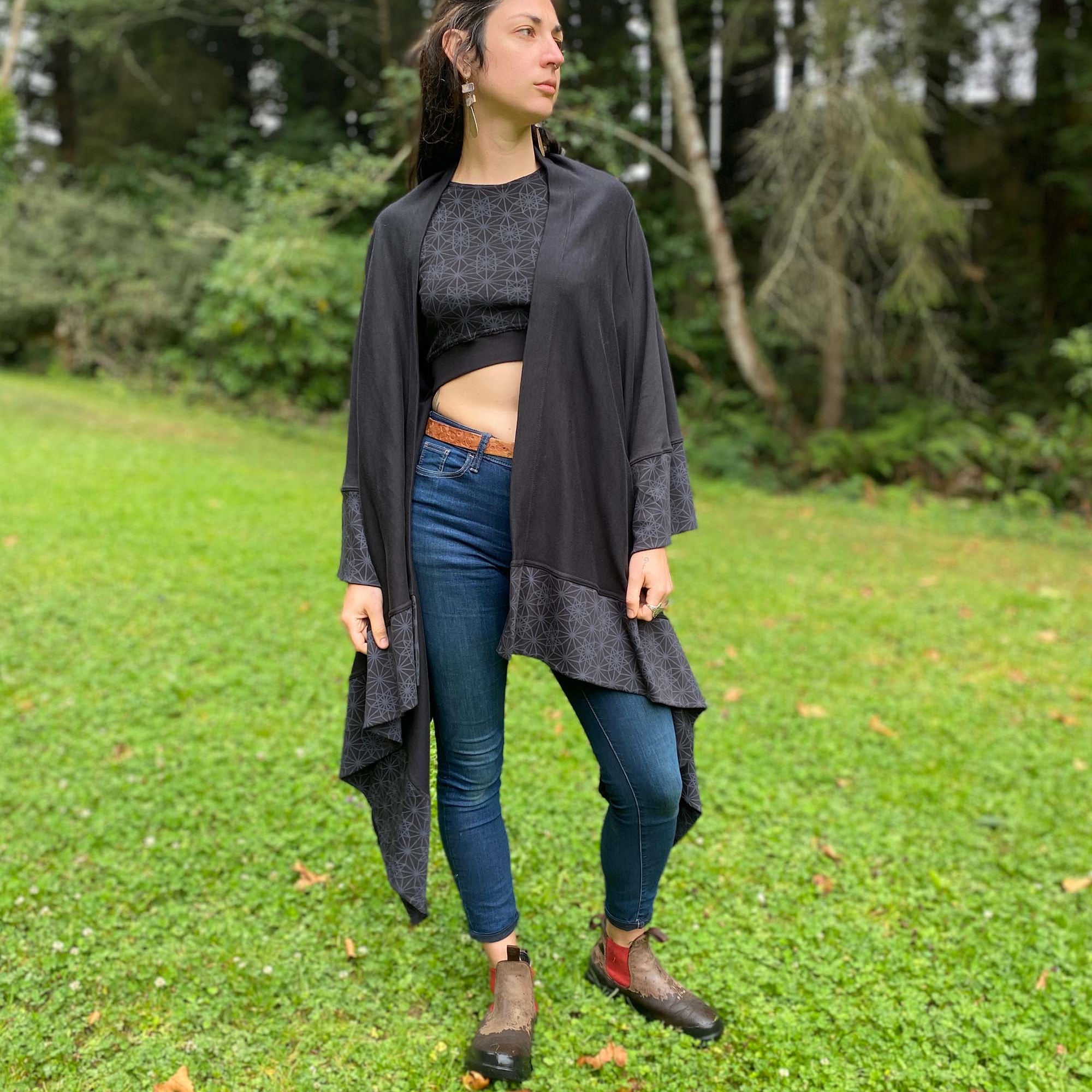 Organic cotton kimono, black fabric with geometric printed accents, front view on female model.