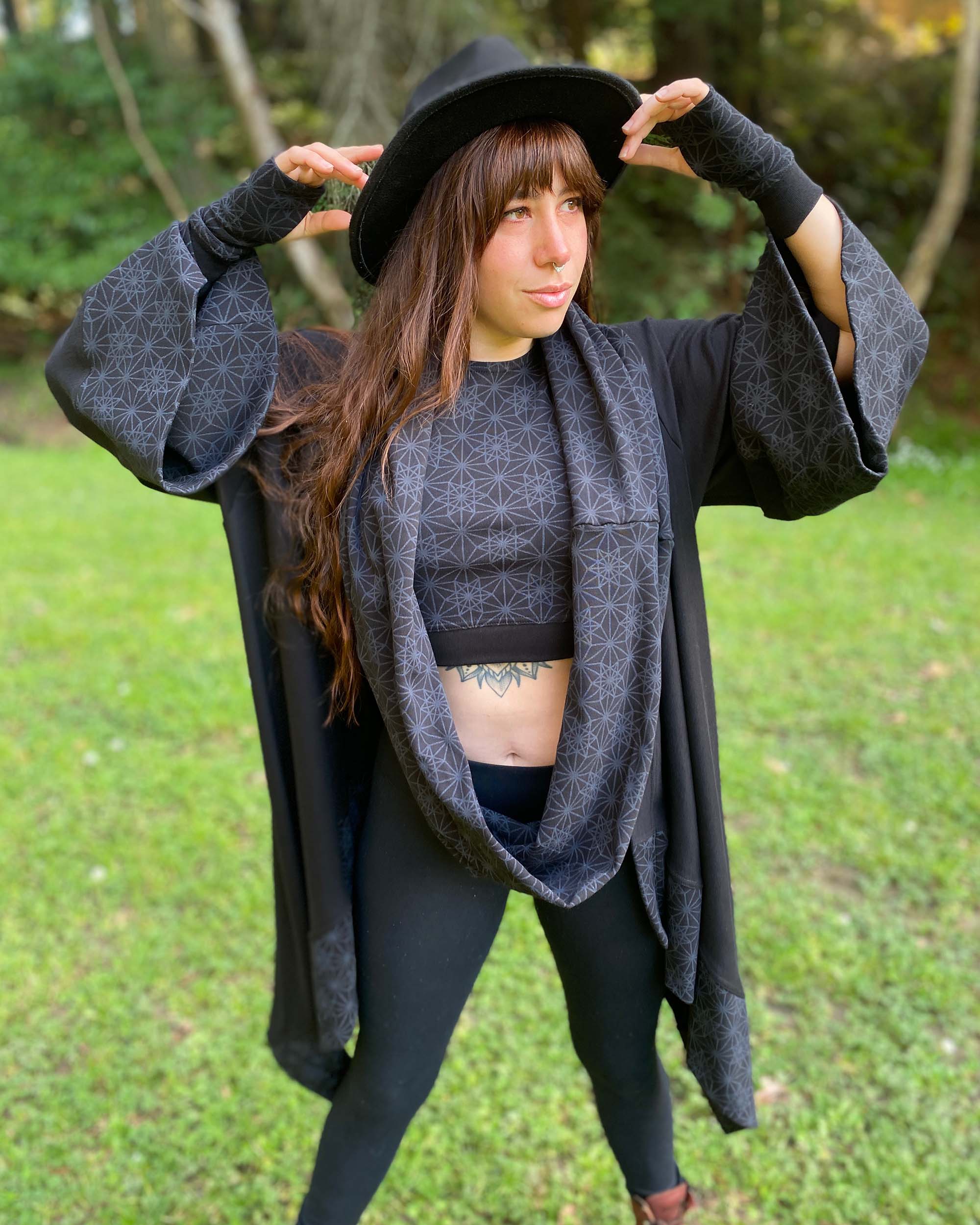 Organic cotton black kimono, scarf, and hand warmers with geometric print accents, front view on female model.