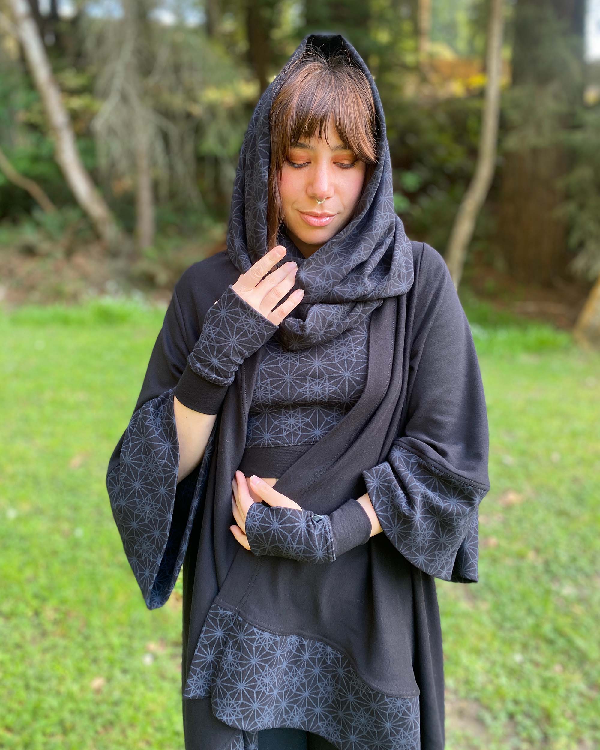 Organic cotton kimono, black with geometric print, front view on female model with matching black garments.