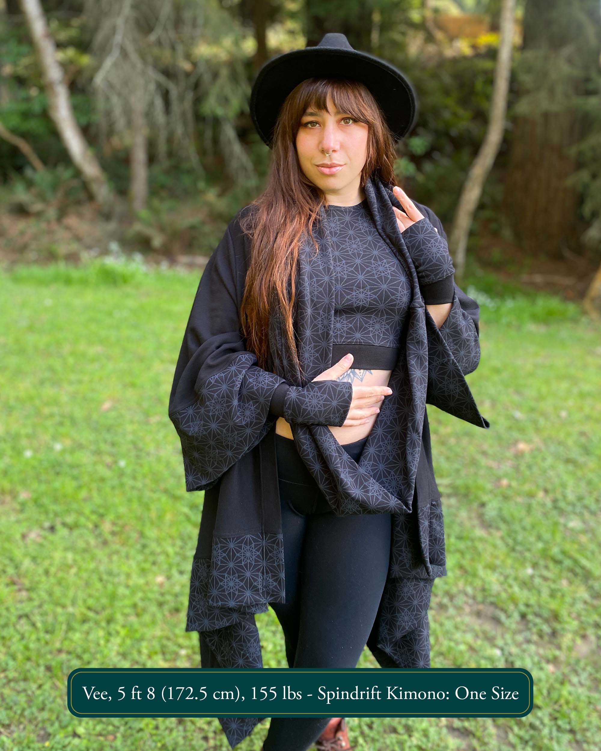 Organic cotton kimono, black fabric with geometric print accents, front view on female model in nature.