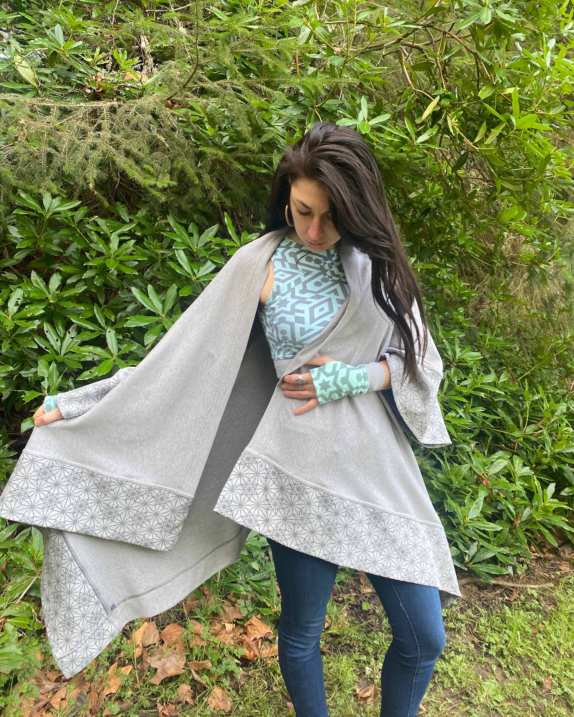 Organic cotton kimono, grey fabric with geometric print accents, front view on female model in the outdoors.