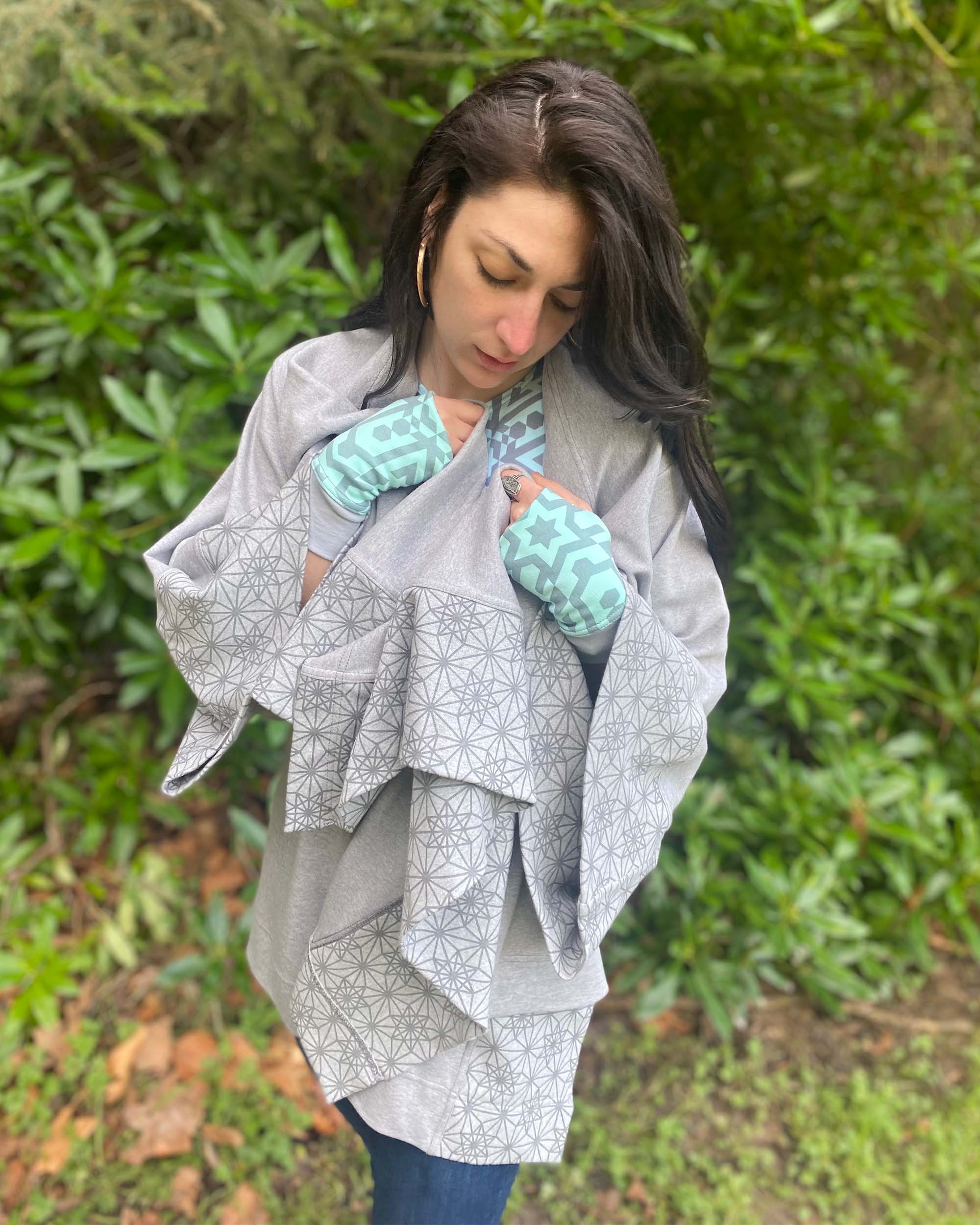 Organic cotton kimono, grey fabric with geometric print accents, front view on female model all bundled up