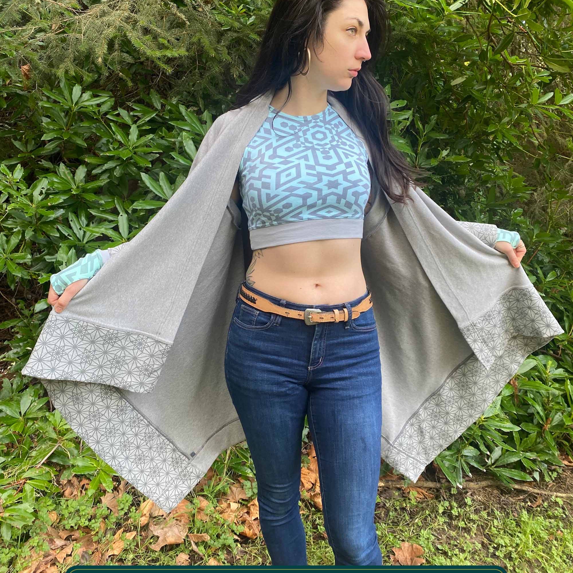 Organic cotton kimono, grey fabric with geometric print accents, front view on female model in nature.