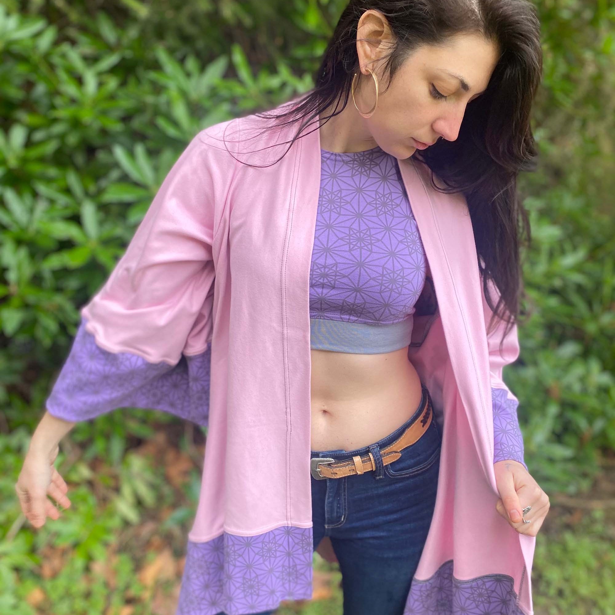 Organic cotton kimono, pink with geometric print and lavender accents, front view on female model.