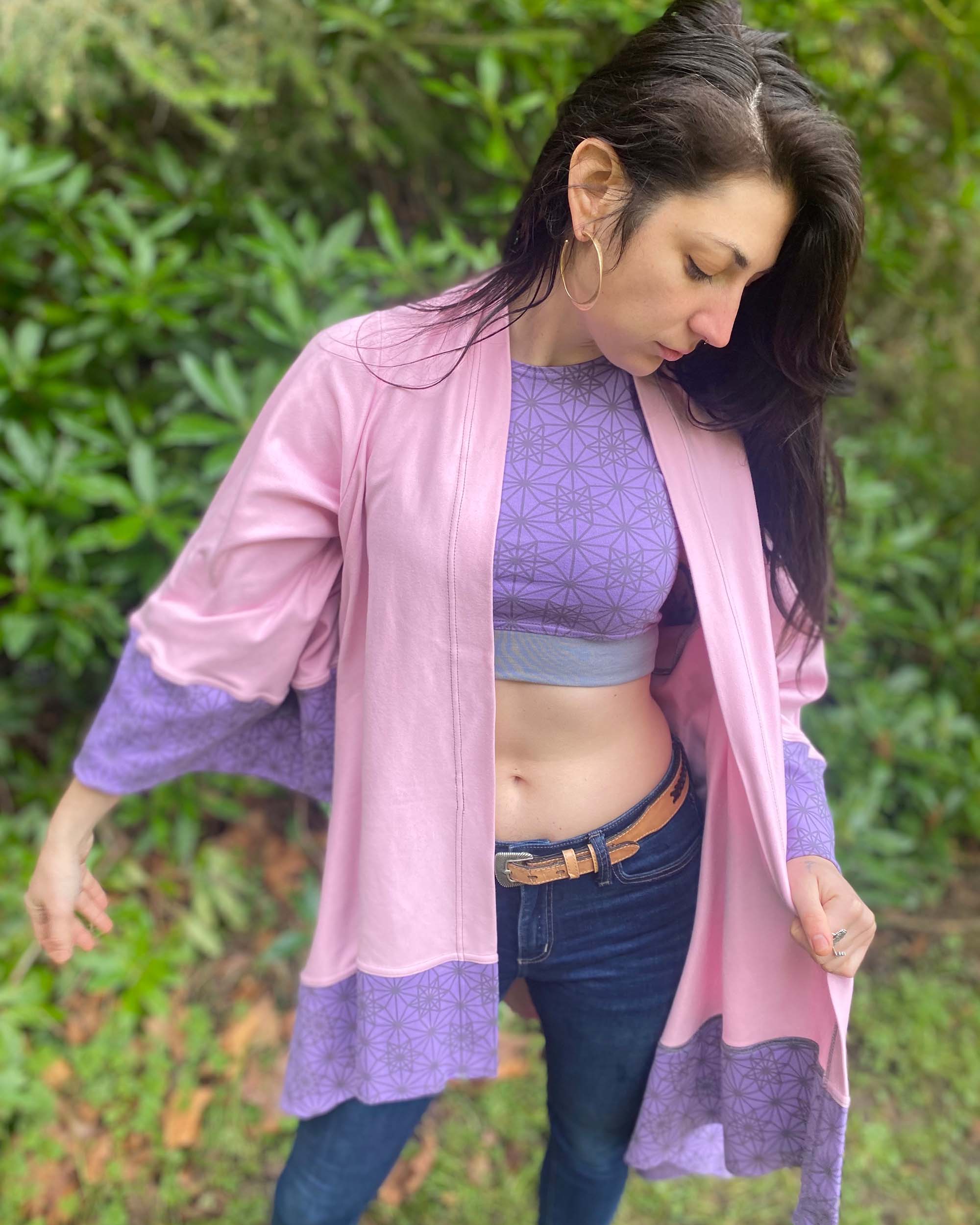 Organic cotton kimono, pink with geometric print and lavender accents, front view on female model.