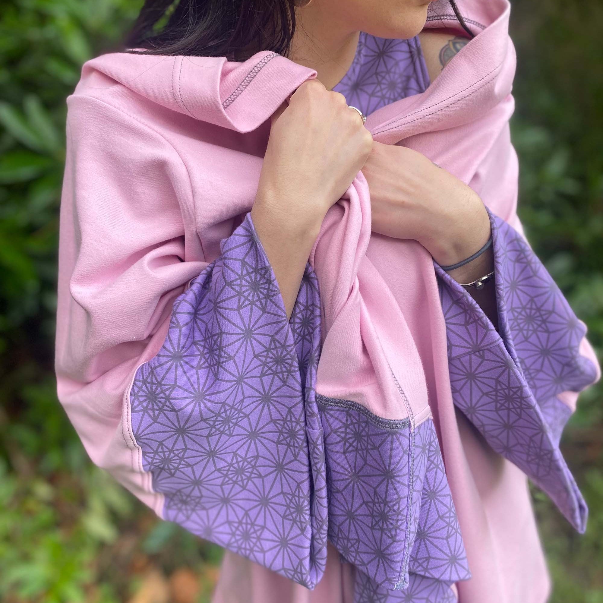 Organic cotton kimono, pink with geometric print and lavender accents, front close up view of fabric.
