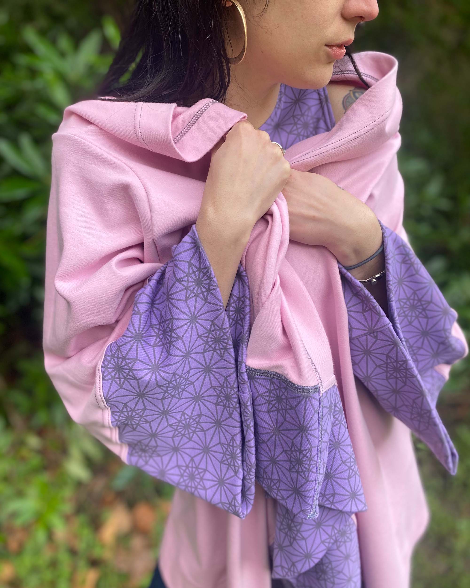 Organic cotton kimono, pink with geometric print and lavender accents, front close up view of fabric.