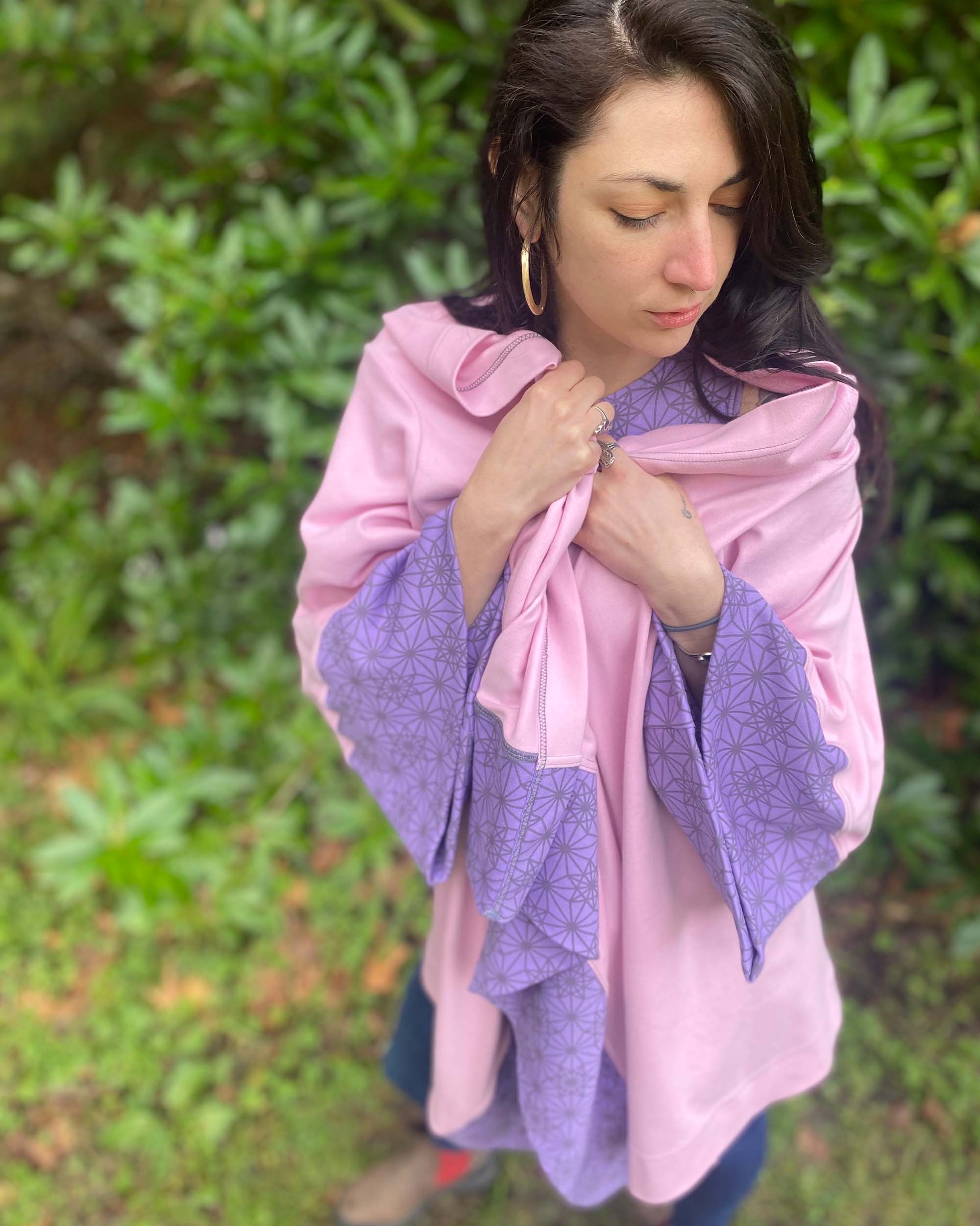 Organic cotton kimono, pink with geometric print and lavender accents, front view of bundled up on female model.