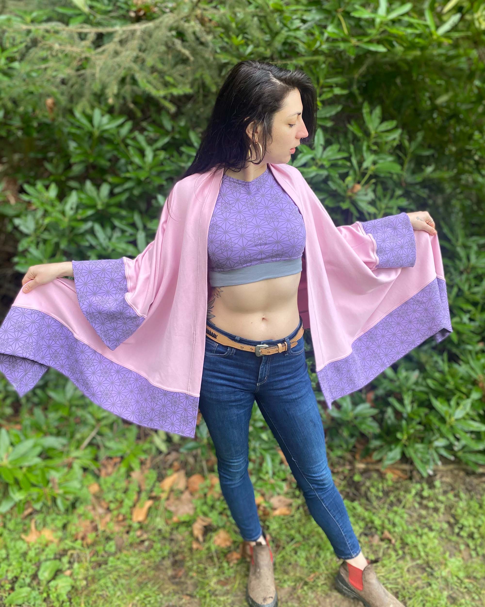 Organic cotton kimono, pink with geo print and lavender accents, front view worn by female model.