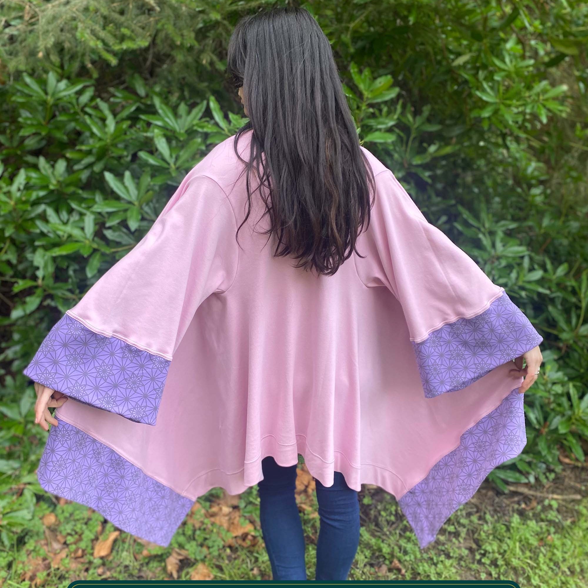 Organic cotton kimono, pink with geometric print and lavender accents, back view on female model.