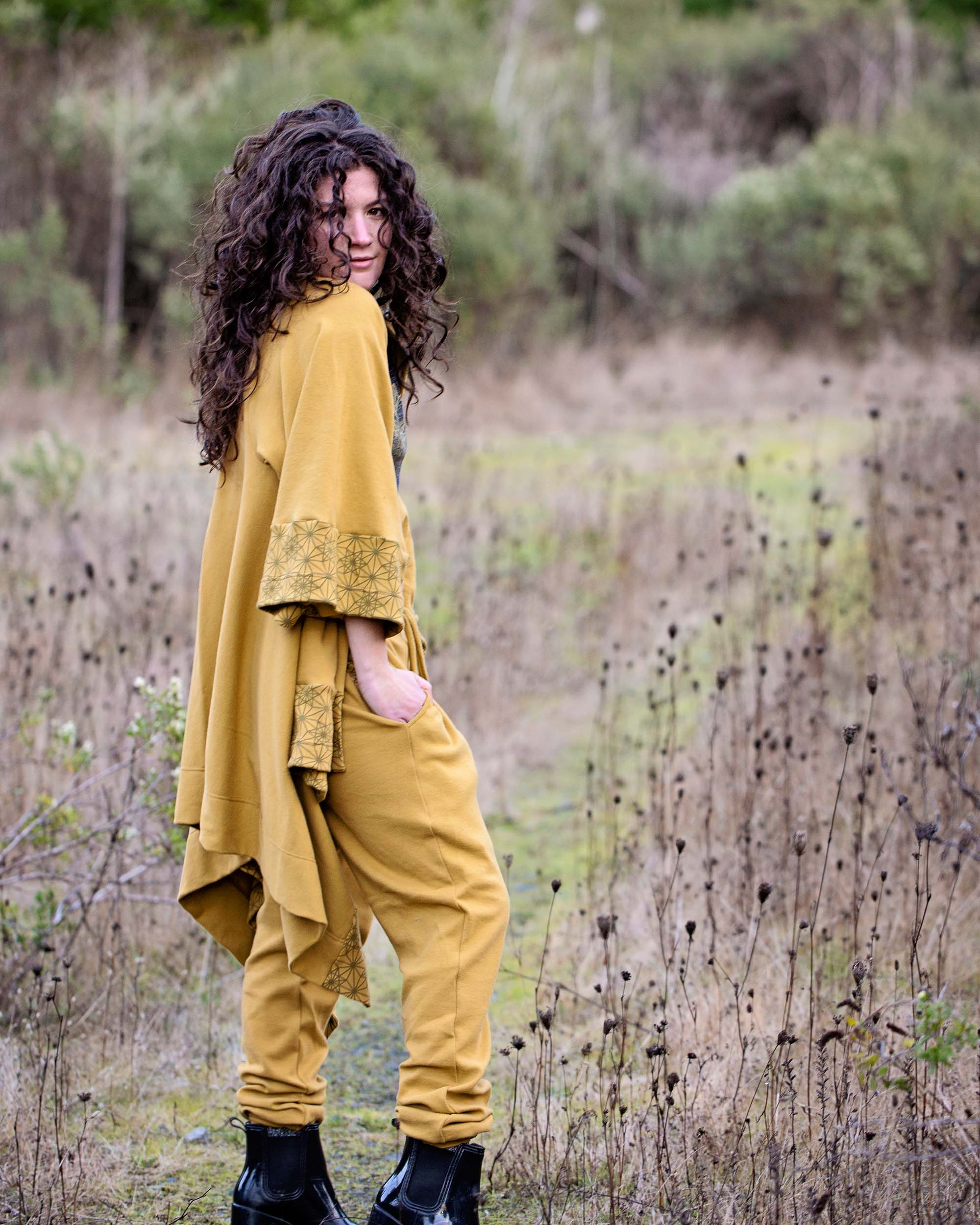 Organic cotton kimono, yellow fabric with geometric print accents, right side view on model in nature.