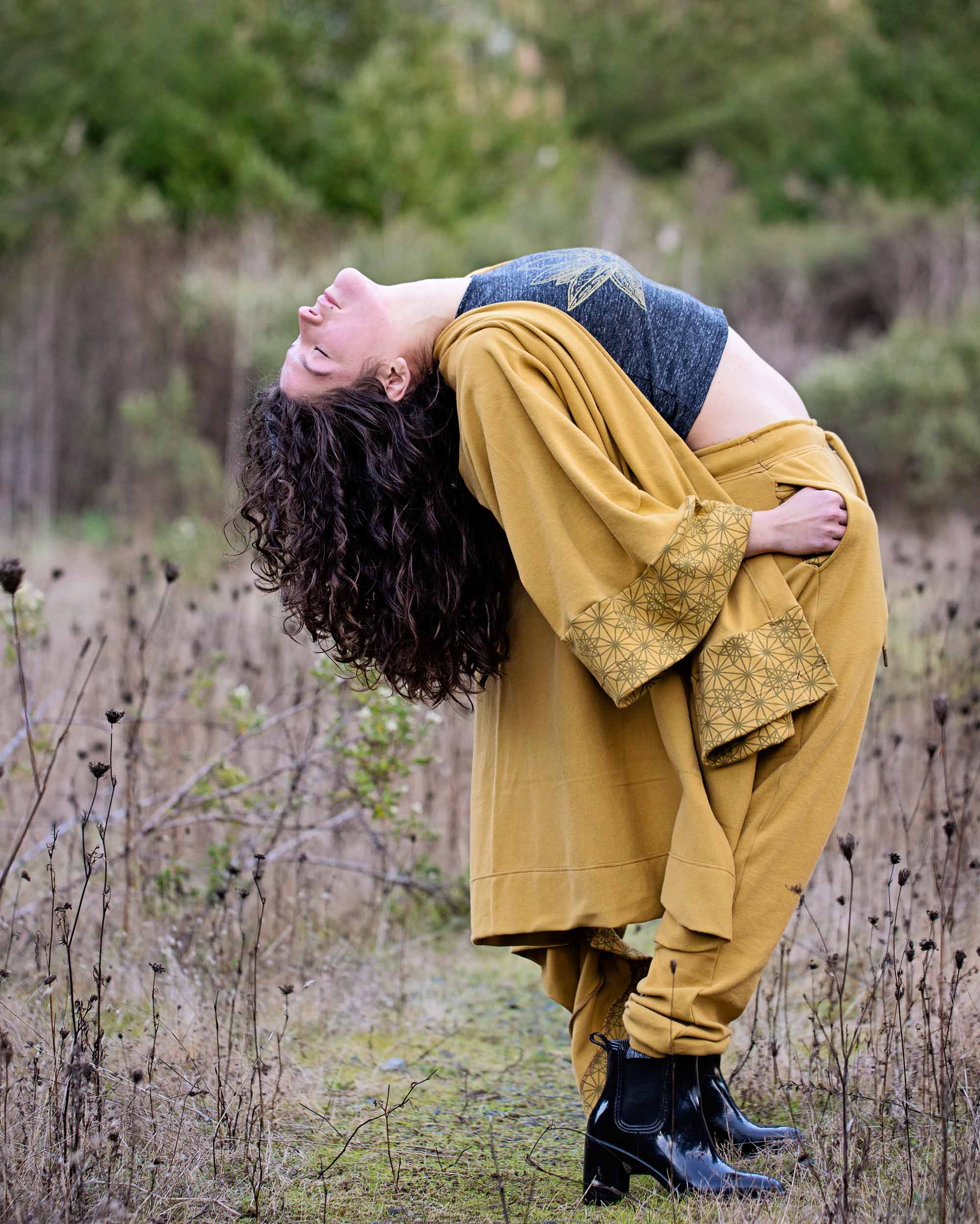 Organic cotton kimono, yellow fabric with geometric print accents, right side view on model in nature.