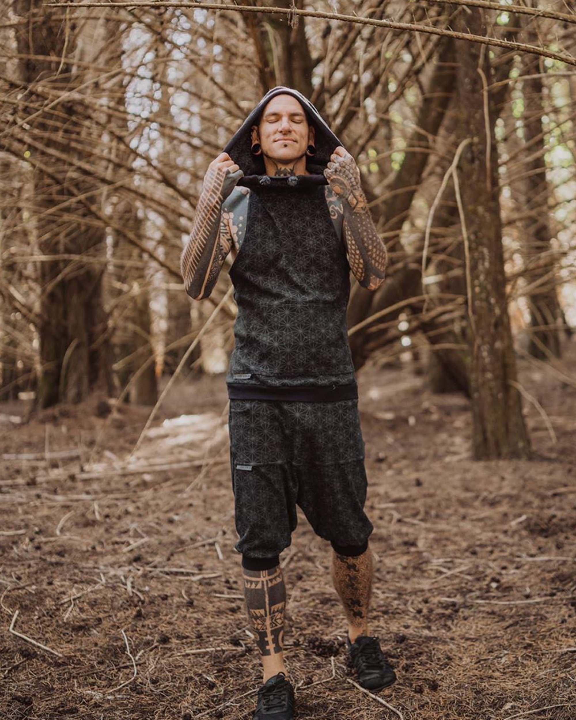 Organic cotton matching hooded tank top and shorts, black fabric with geometric print, full body view on model.