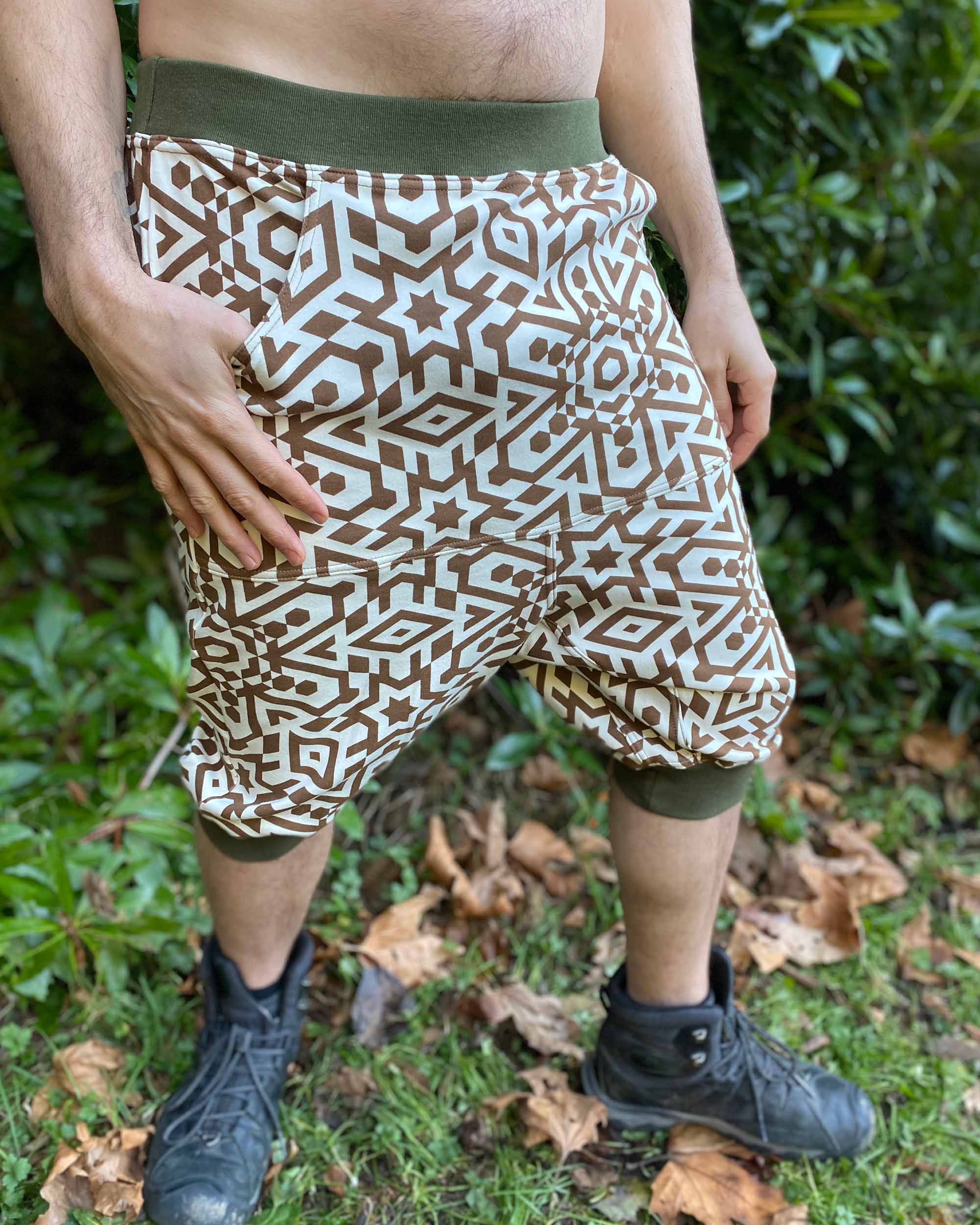 Organic cotton drop crotch shorts, un-dyed fabric with brown geometric print, front view on male model.