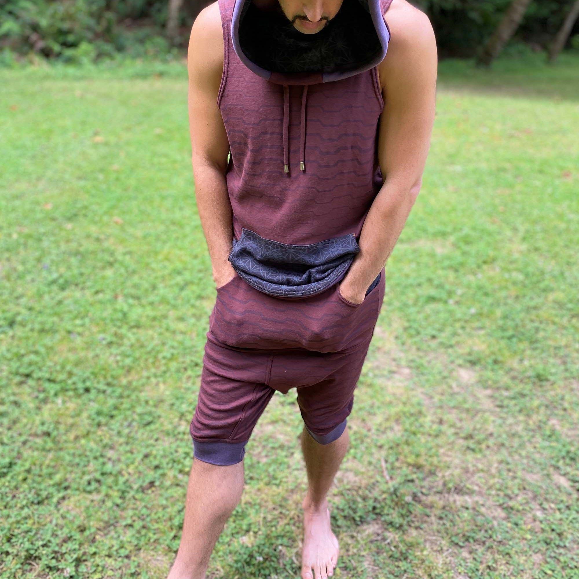 Cowl hood tank top and drop crotch shorts, brown fabric with geometric stripes, front view on male model.