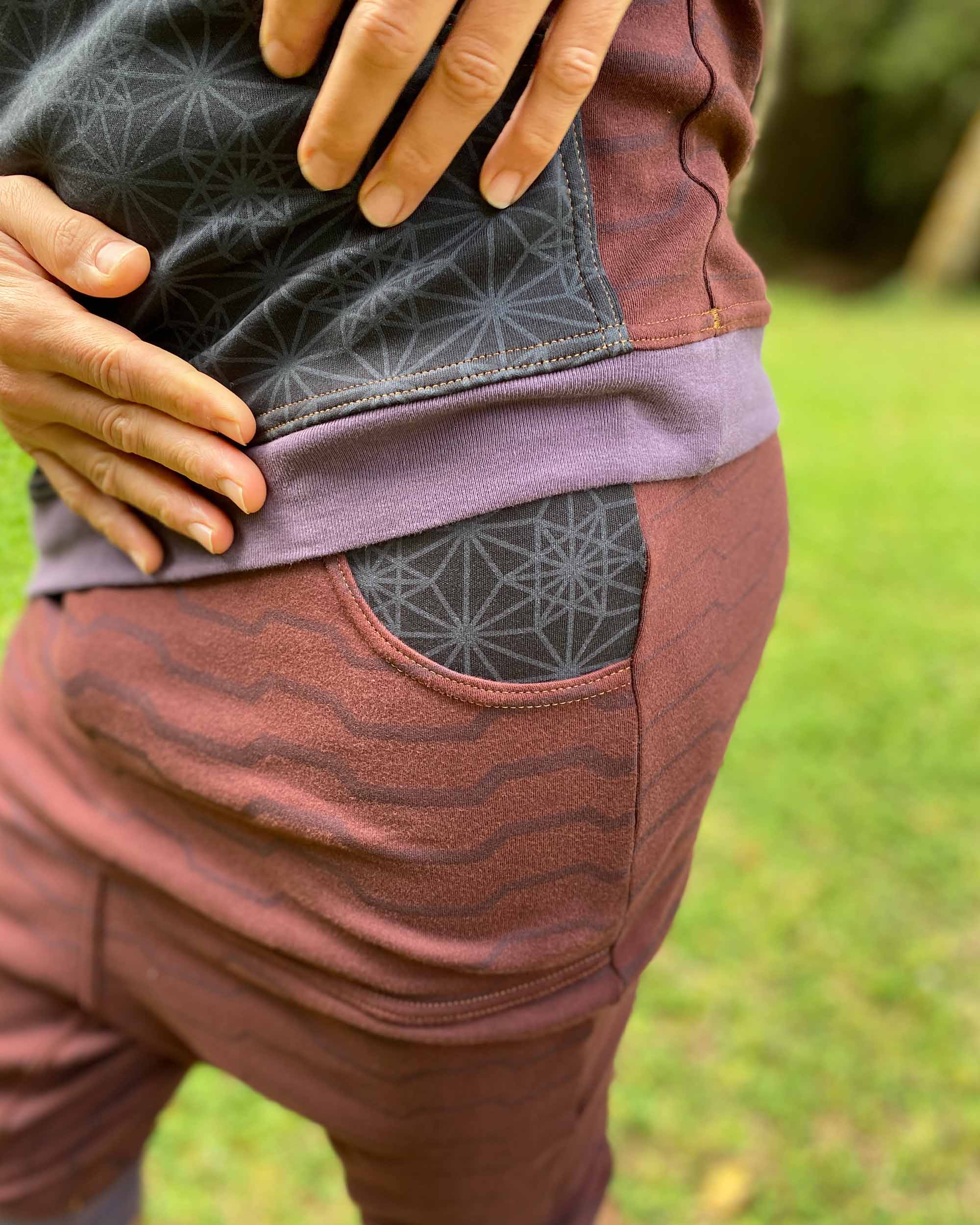 Organic cotton drop crotch shorts, reddish brown fabric with geometric stripes, detail view of the pocket.