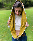 Un-dyed and yellow organic cotton infinity scarf with sacred geometry prints, front view on model.