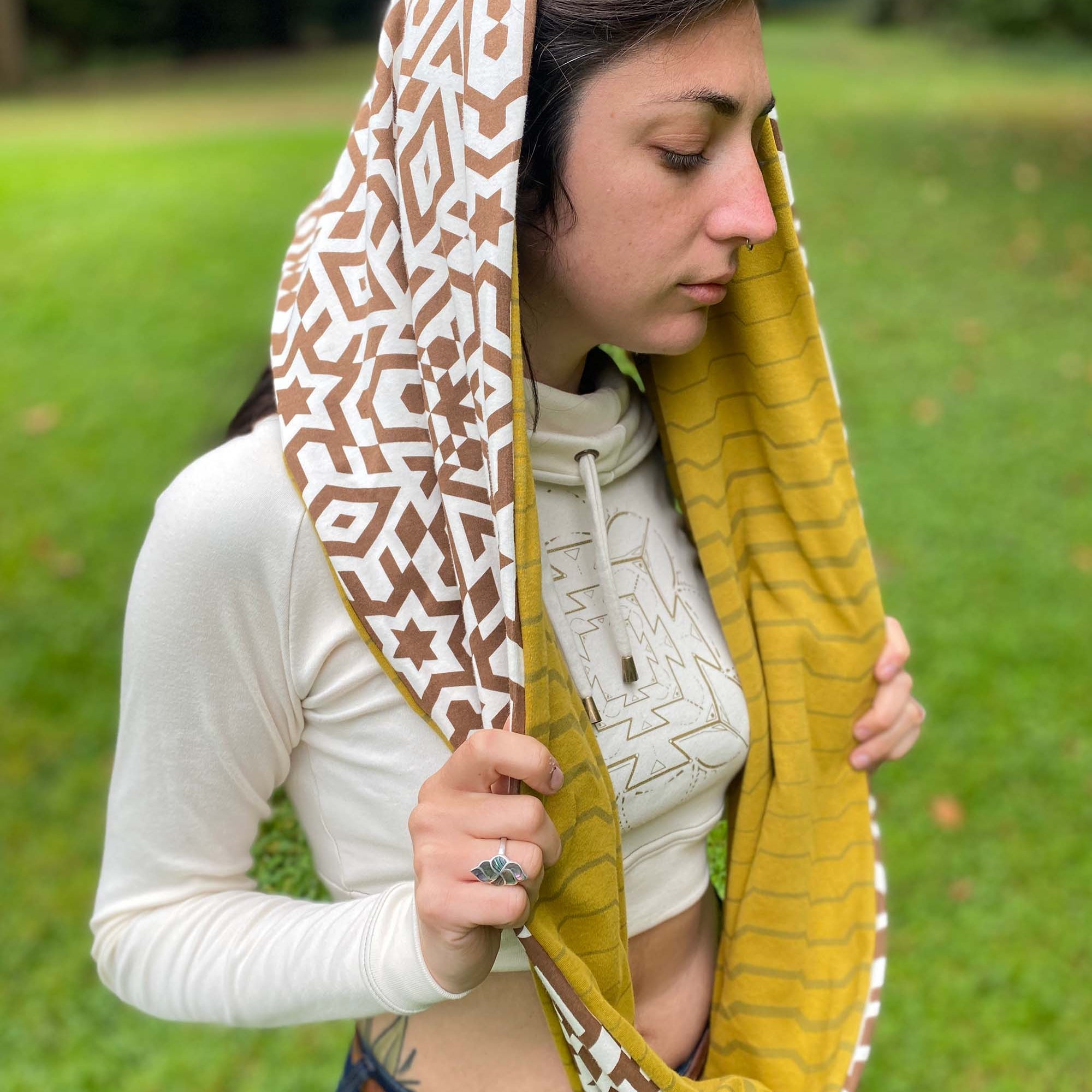 Un-dyed and yellow organic cotton infinity scarf with geometric printed fabric, right side view on female model.