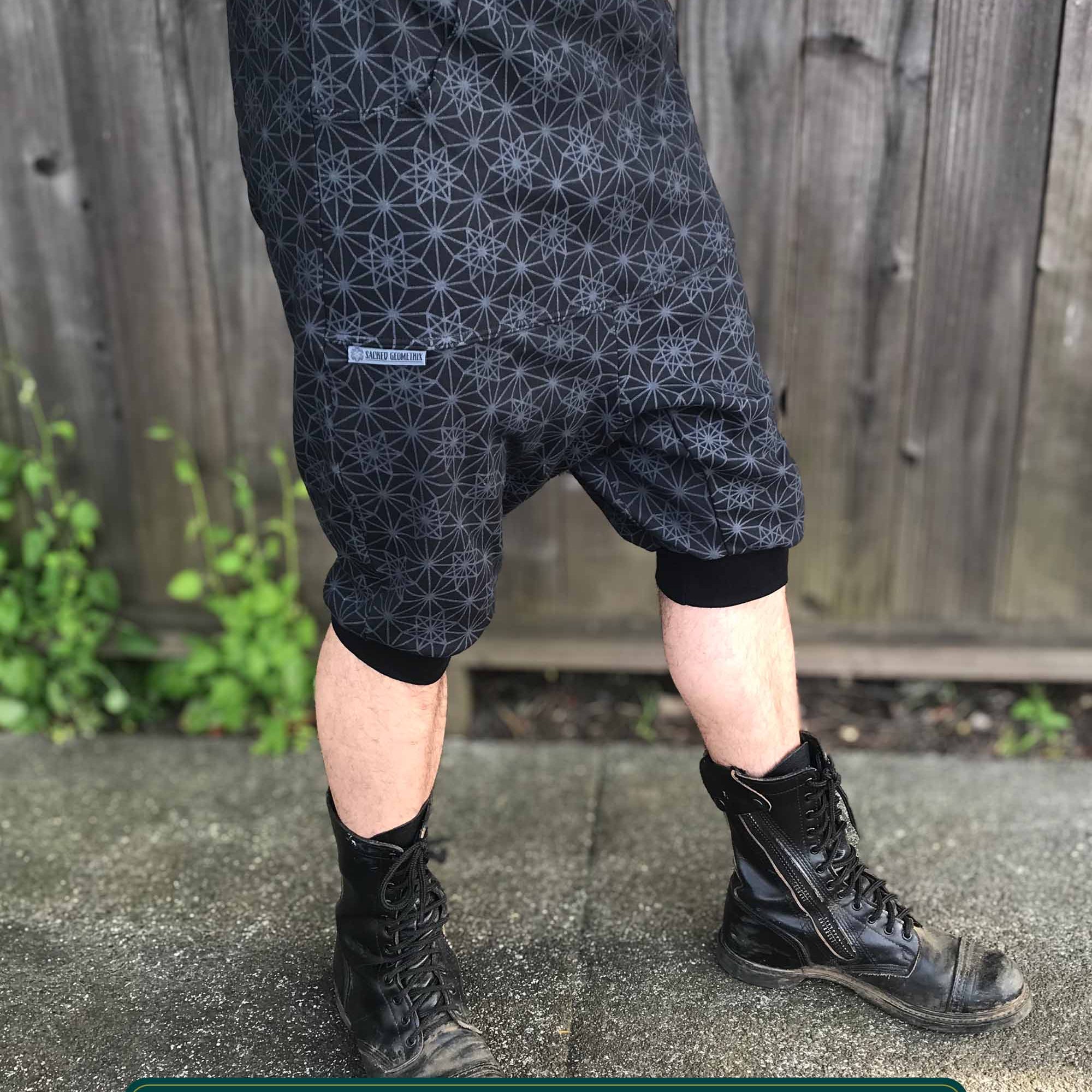 Organic cotton drop crotch shorts, black with geometric fabric print, front right side view on model.