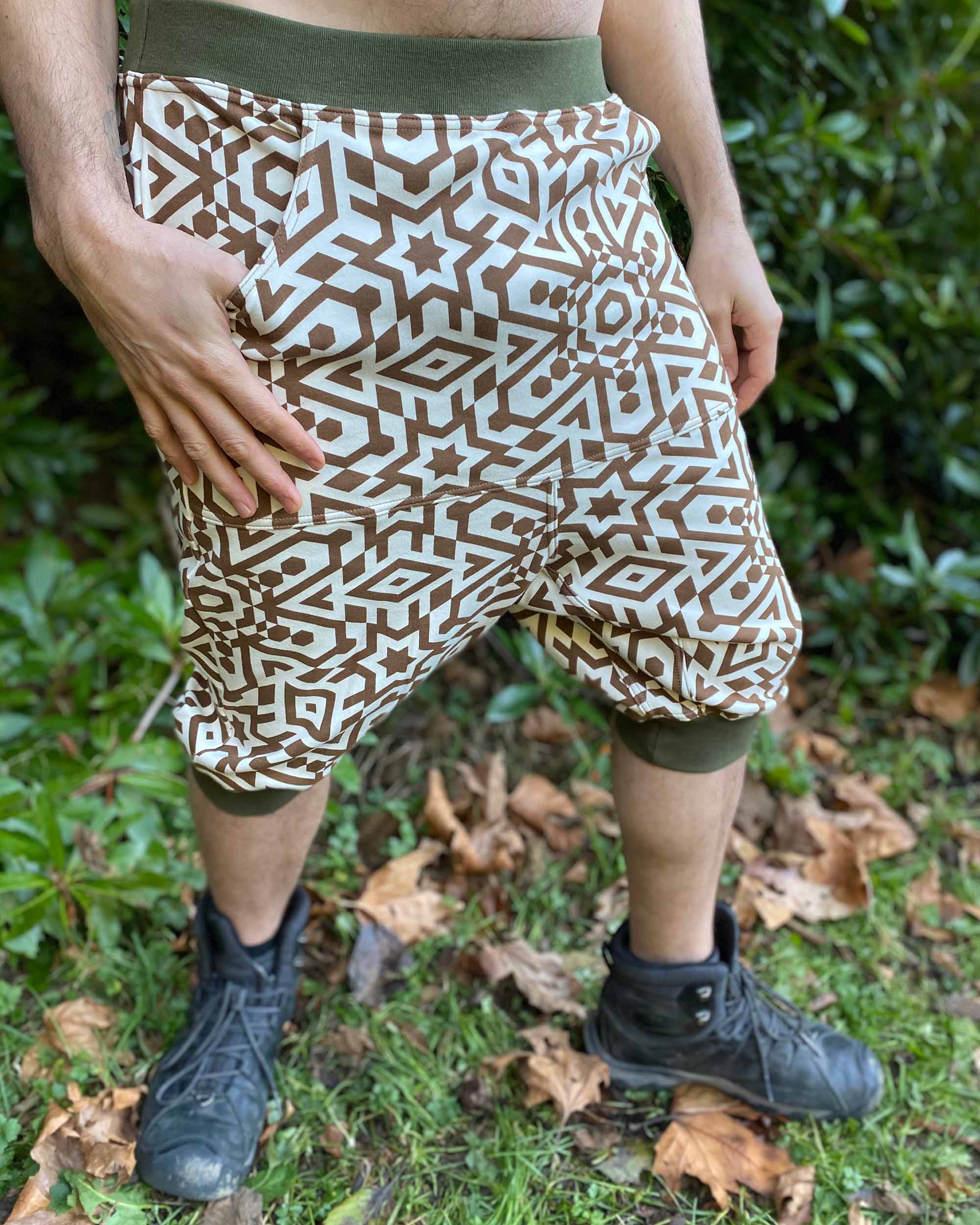 Organic cotton drop crotch shorts, undyed fabric with geometric print, front right view on male model.