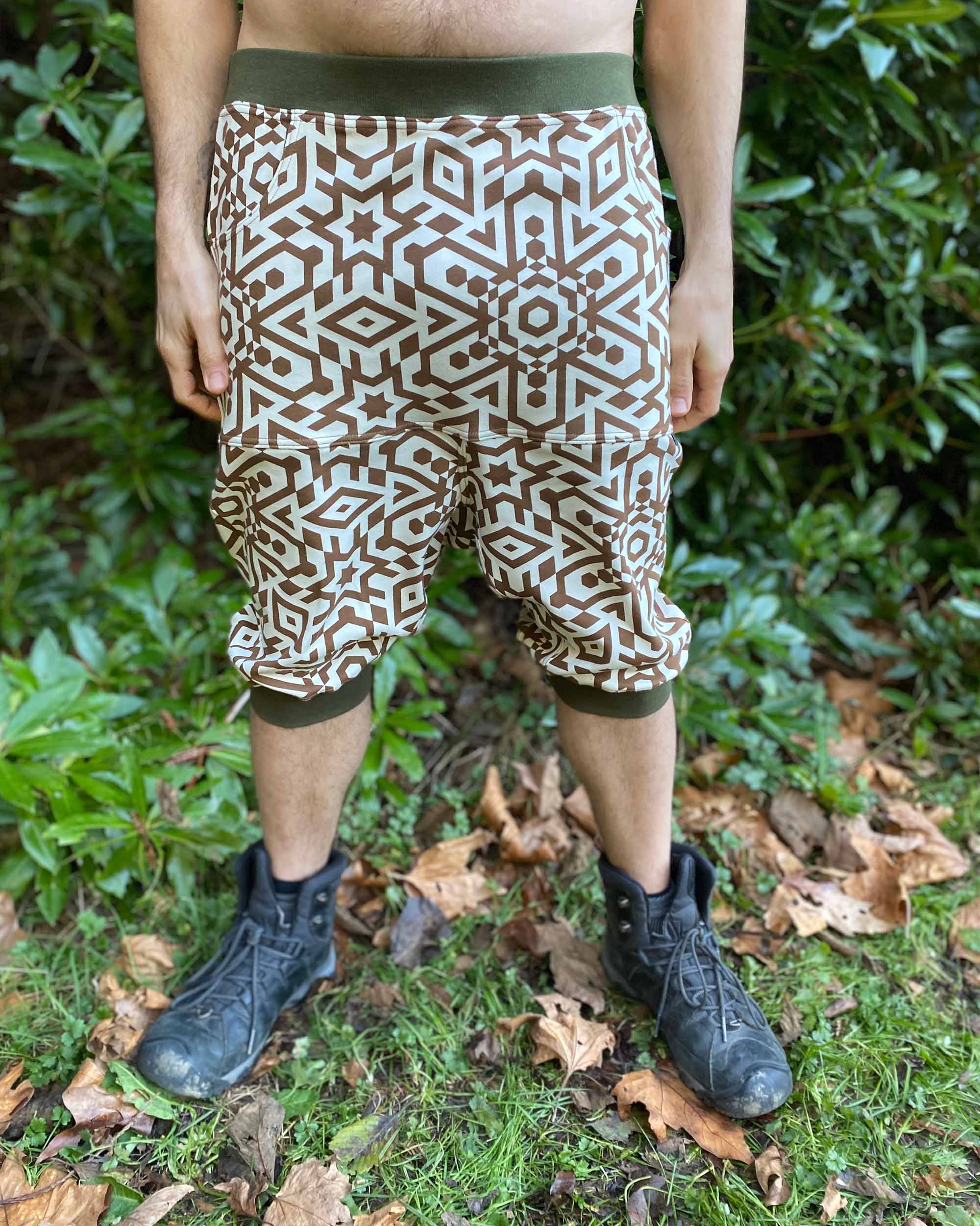 Organic cotton drop crotch shorts, undyed fabric with brown geometric print, front view on male model.