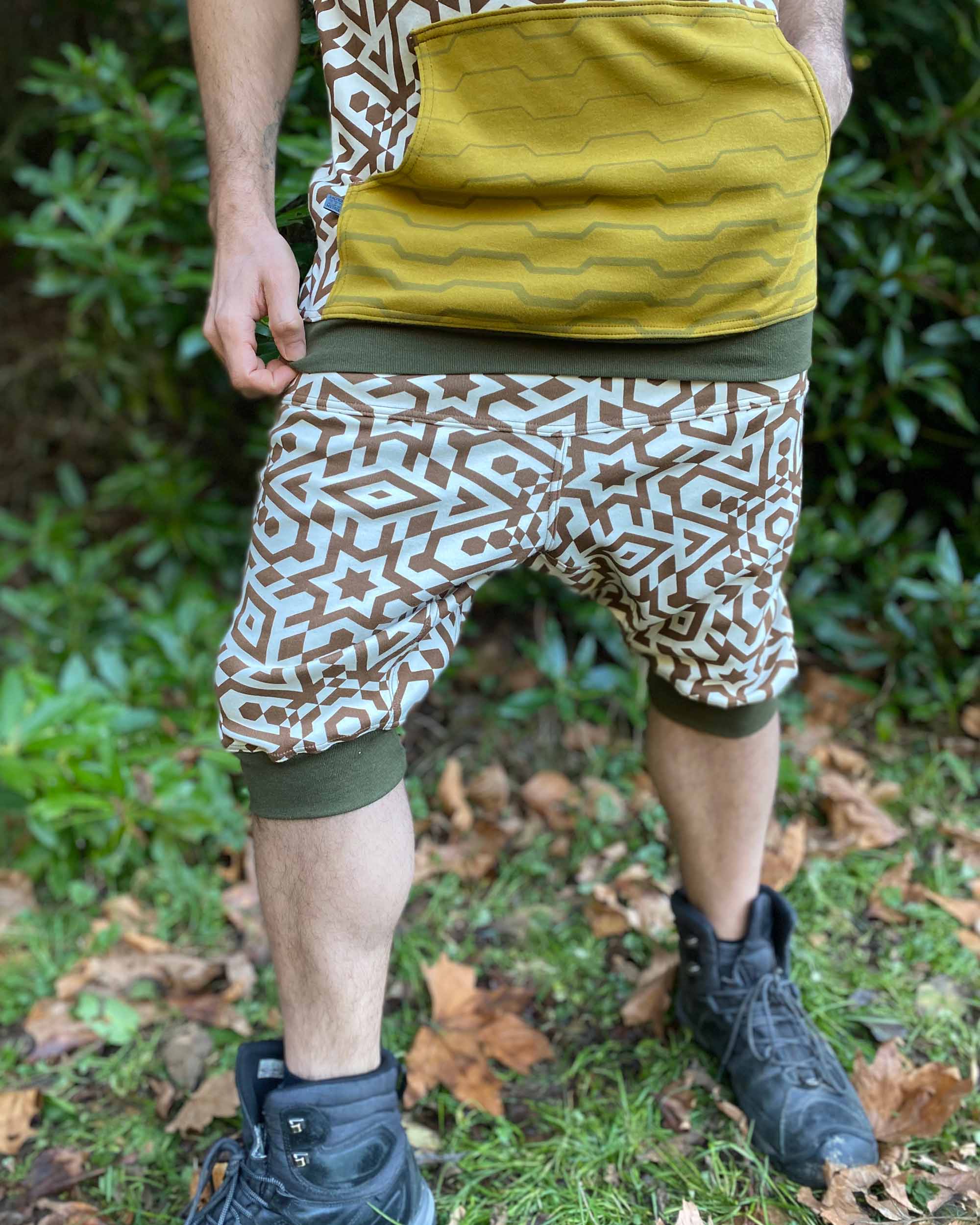 Organic cotton drop crotch shorts, undyed fabric with brown geometric print, front view on male model.