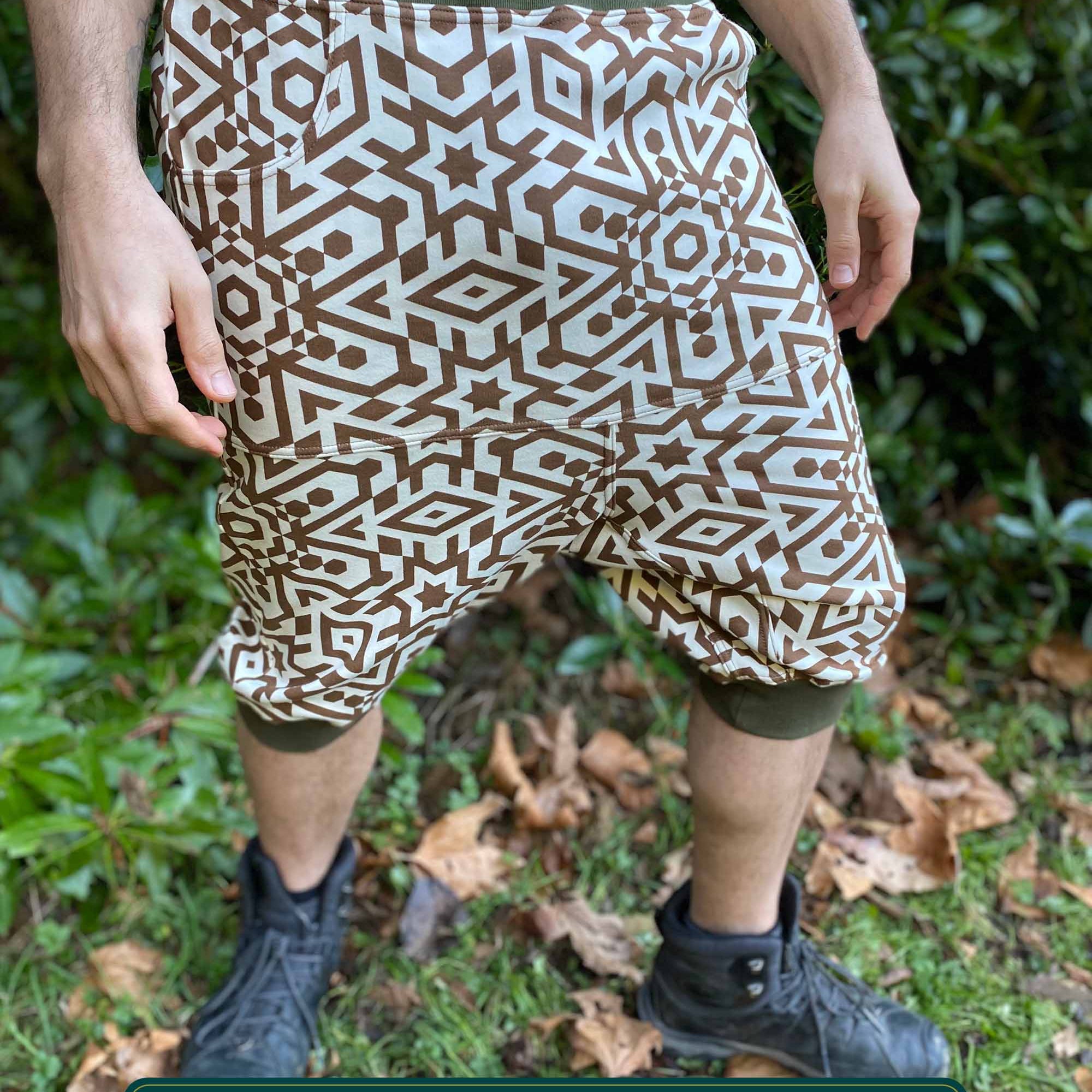 Organic cotton drop crotch shorts, undyed fabric with brown geometric print, front right side view on male model.