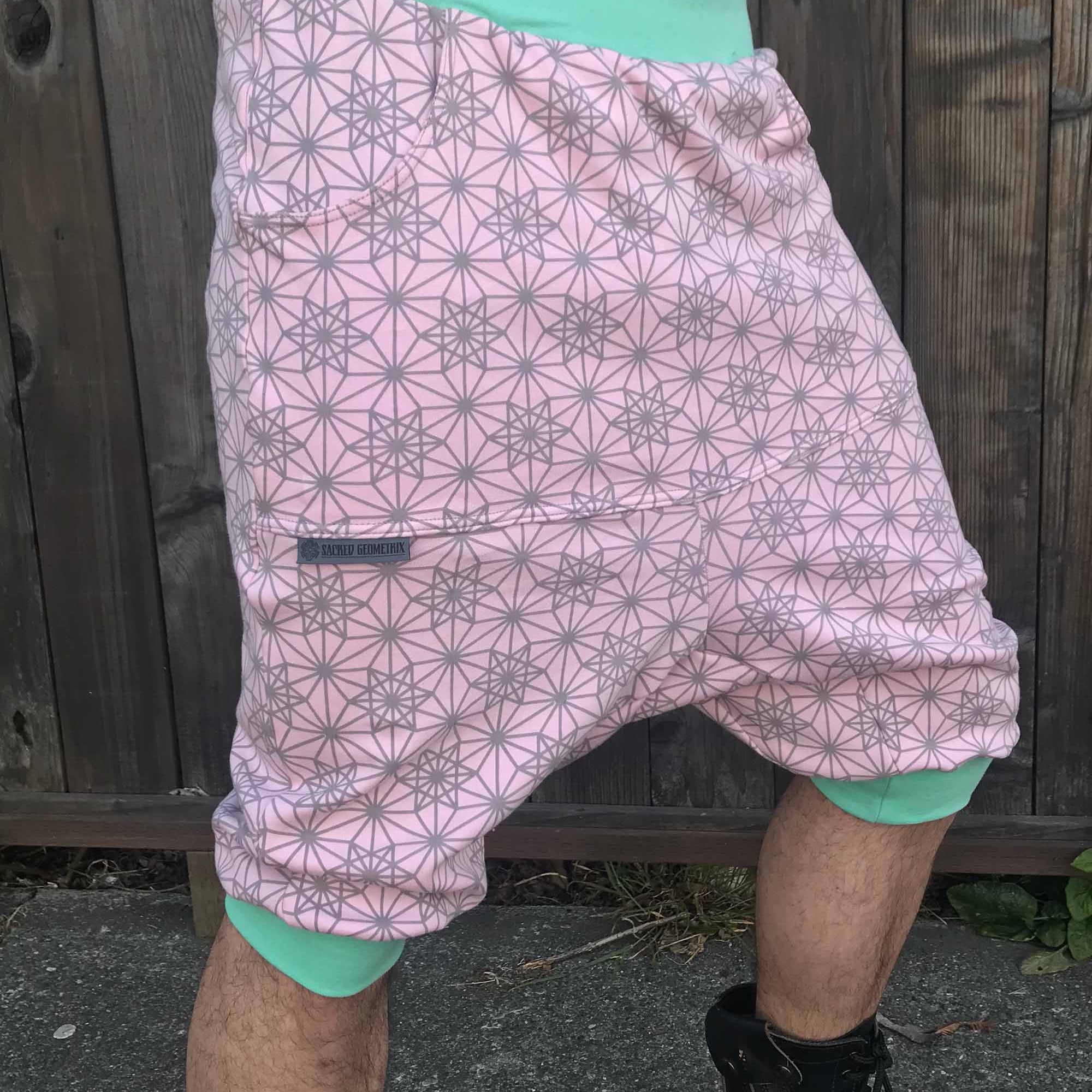 Organic cotton drop crotch shorts, pink with geometric fabric print, front right side view on model.