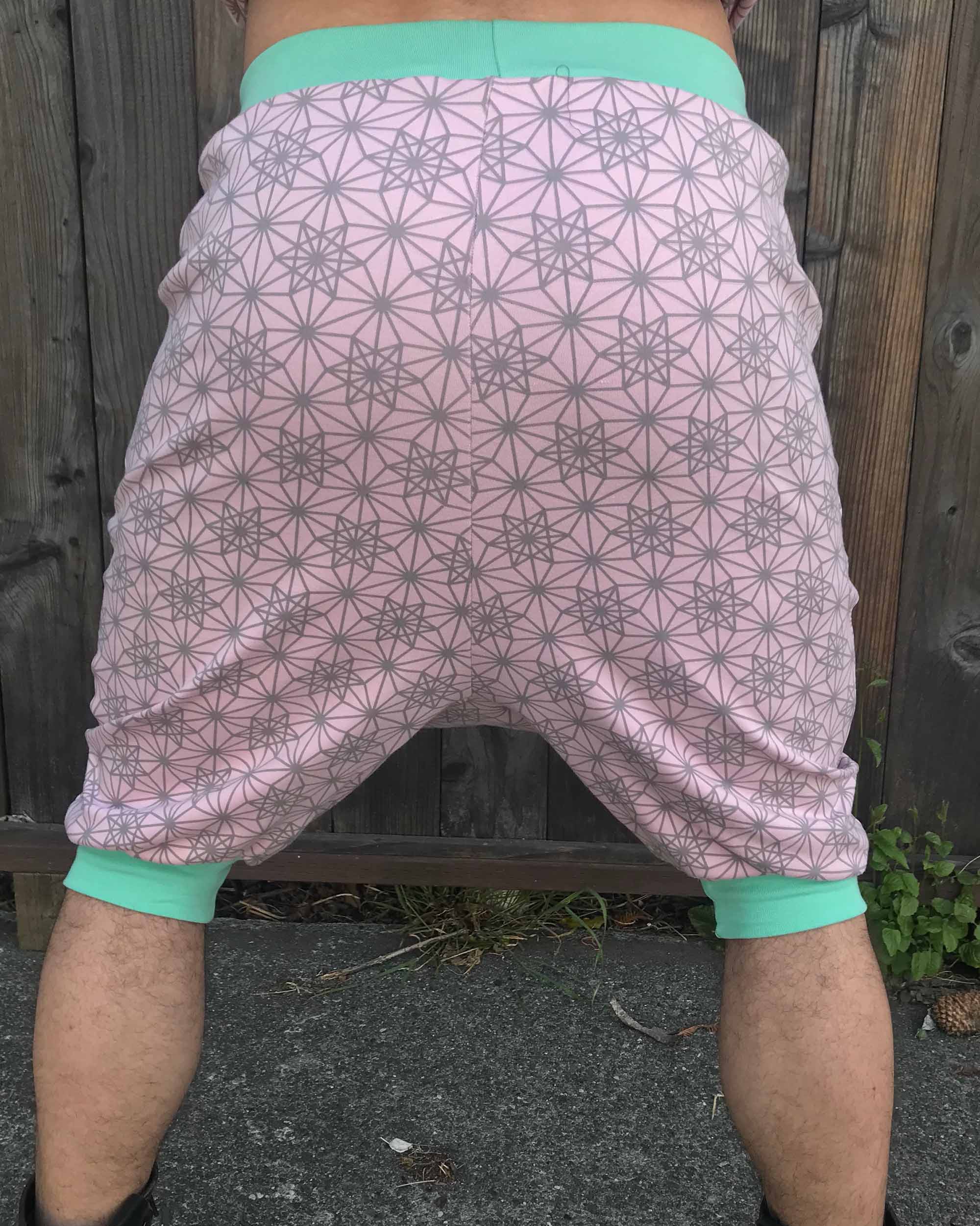 Organic cotton drop crotch shorts, pink with geometric fabric print, back view on model.