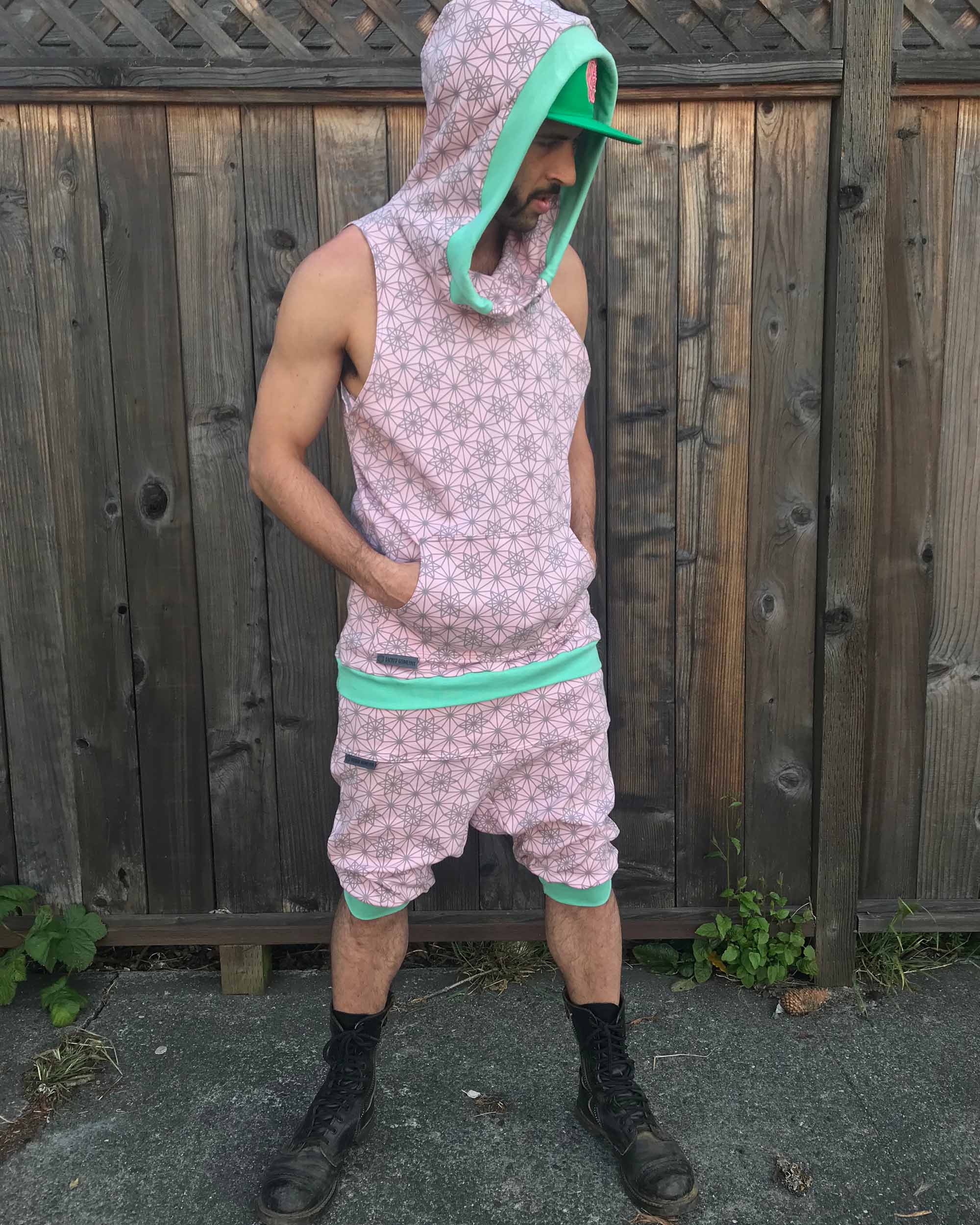 Organic cotton drop crotch shorts, pink with geometric fabric print, front right side view on male model.