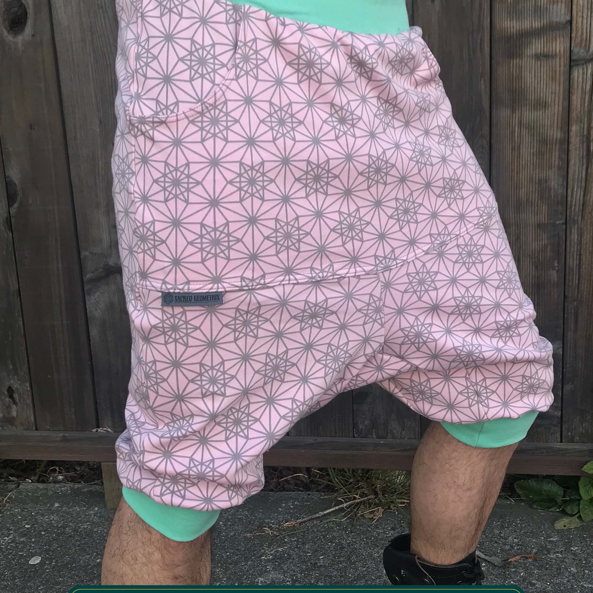 Organic cotton drop crotch shorts, pink with sacred geometry print, right side view on model.