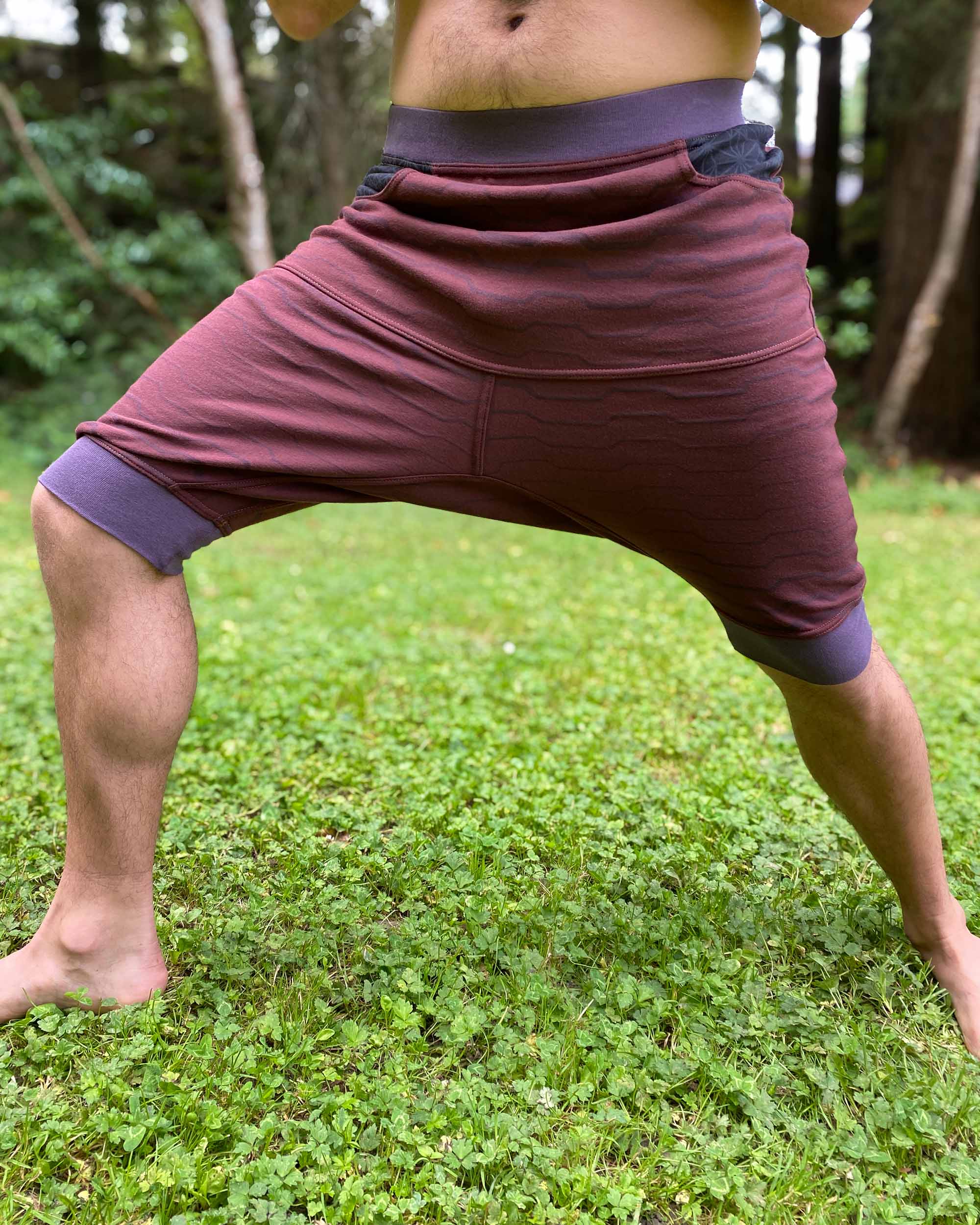 Organic cotton drop crotch shorts, brown fabric with geometric print, front view on male model.