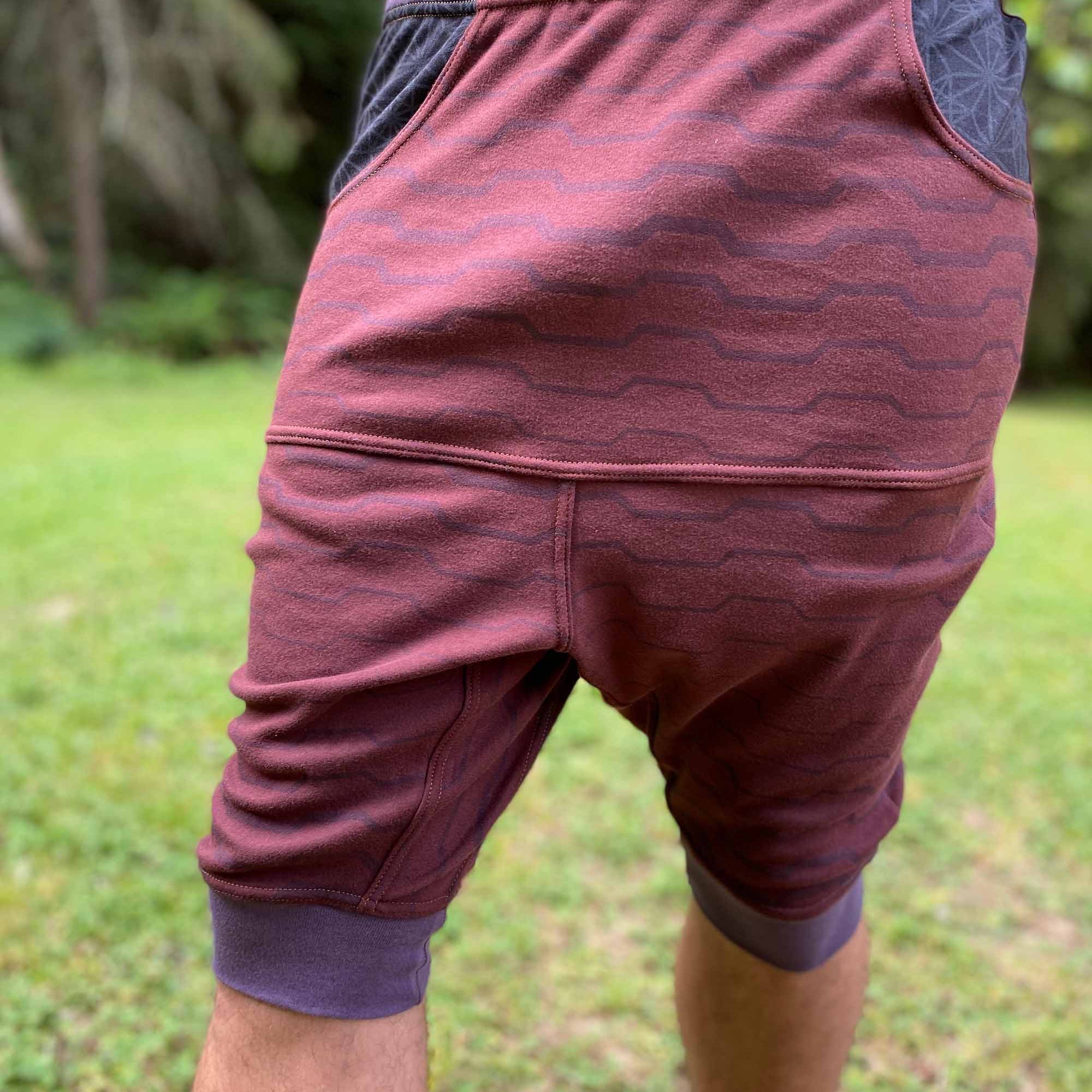 Organic cotton drop crotch shorts, brown fabric with geo print, front view on male model.