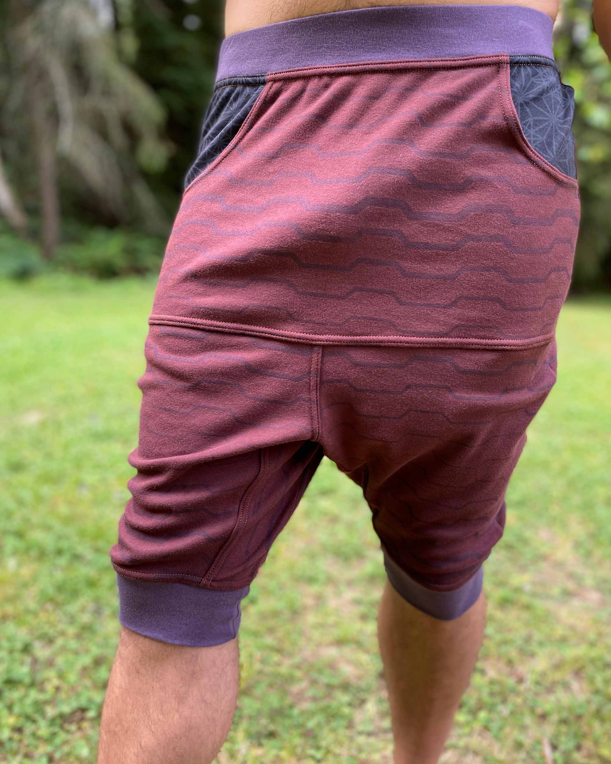 Organic cotton drop crotch shorts, brown fabric with geo print, front view on male model.