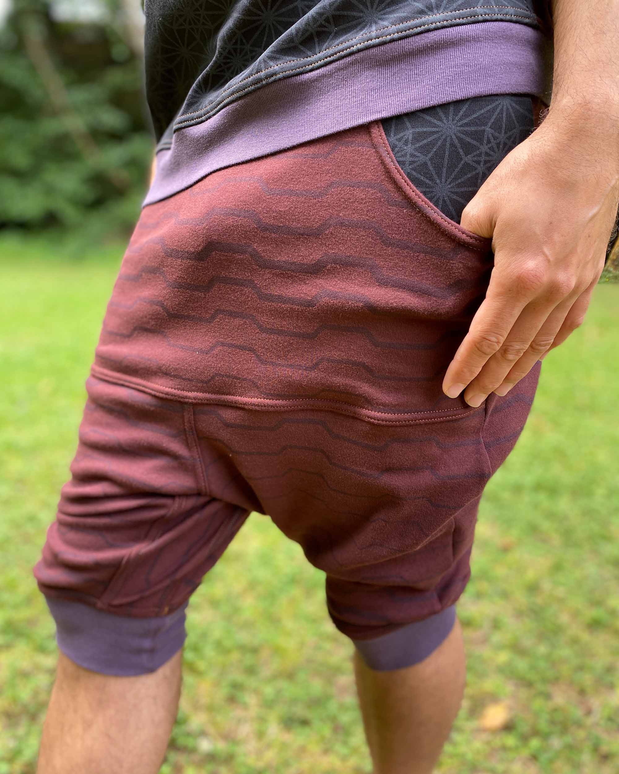 Organic cotton drop crotch shorts, brown fabric with geo print, detail view of pocket.