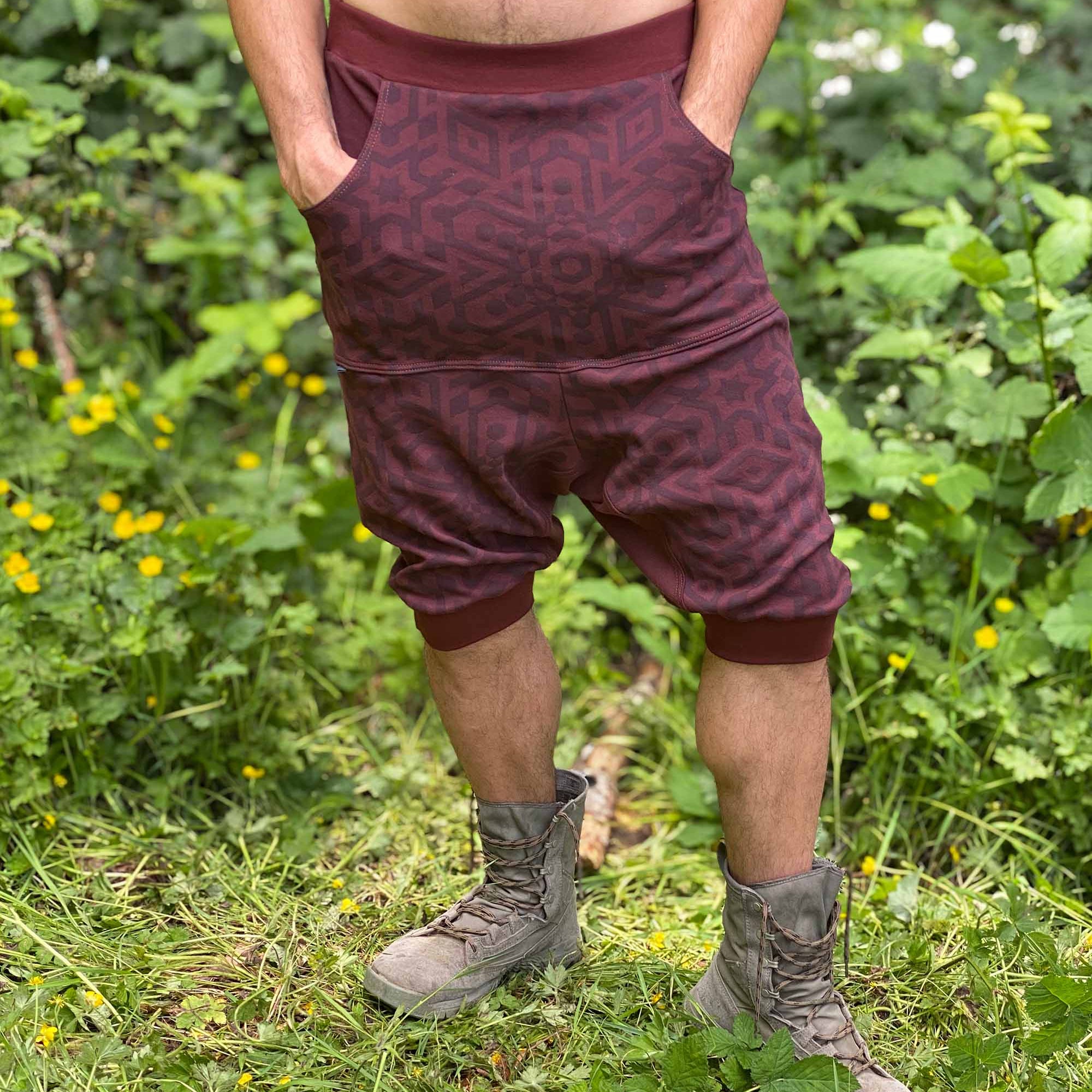 Organic cotton drop crotch shorts, brown fabric with geometric print, front view on male model.