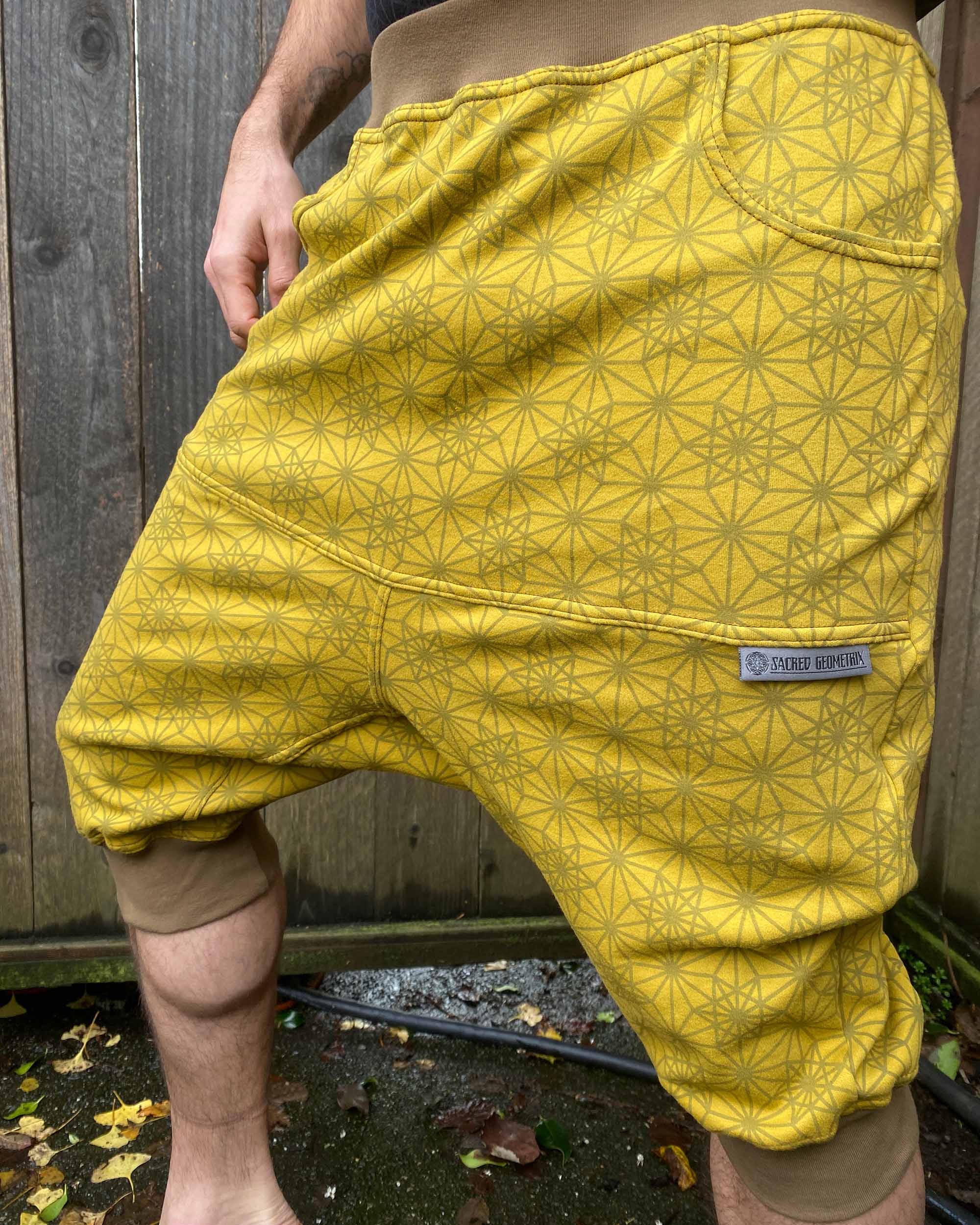 Organic cotton drop crotch shorts, yellow fabric with geometric print, detail view of fabric.