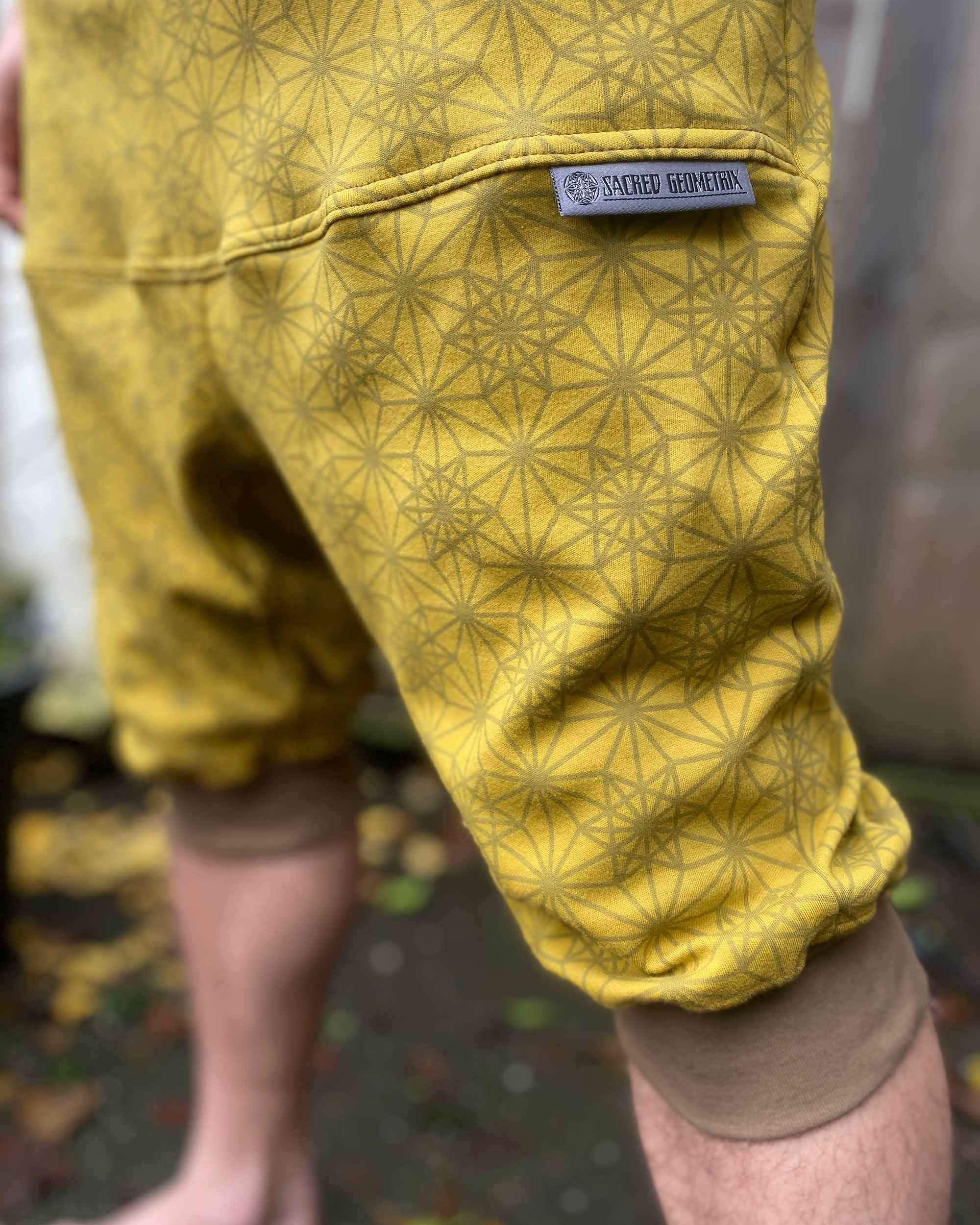 Organic cotton drop crotch shorts, yellow fabric with geometric print, detail view of fabric.