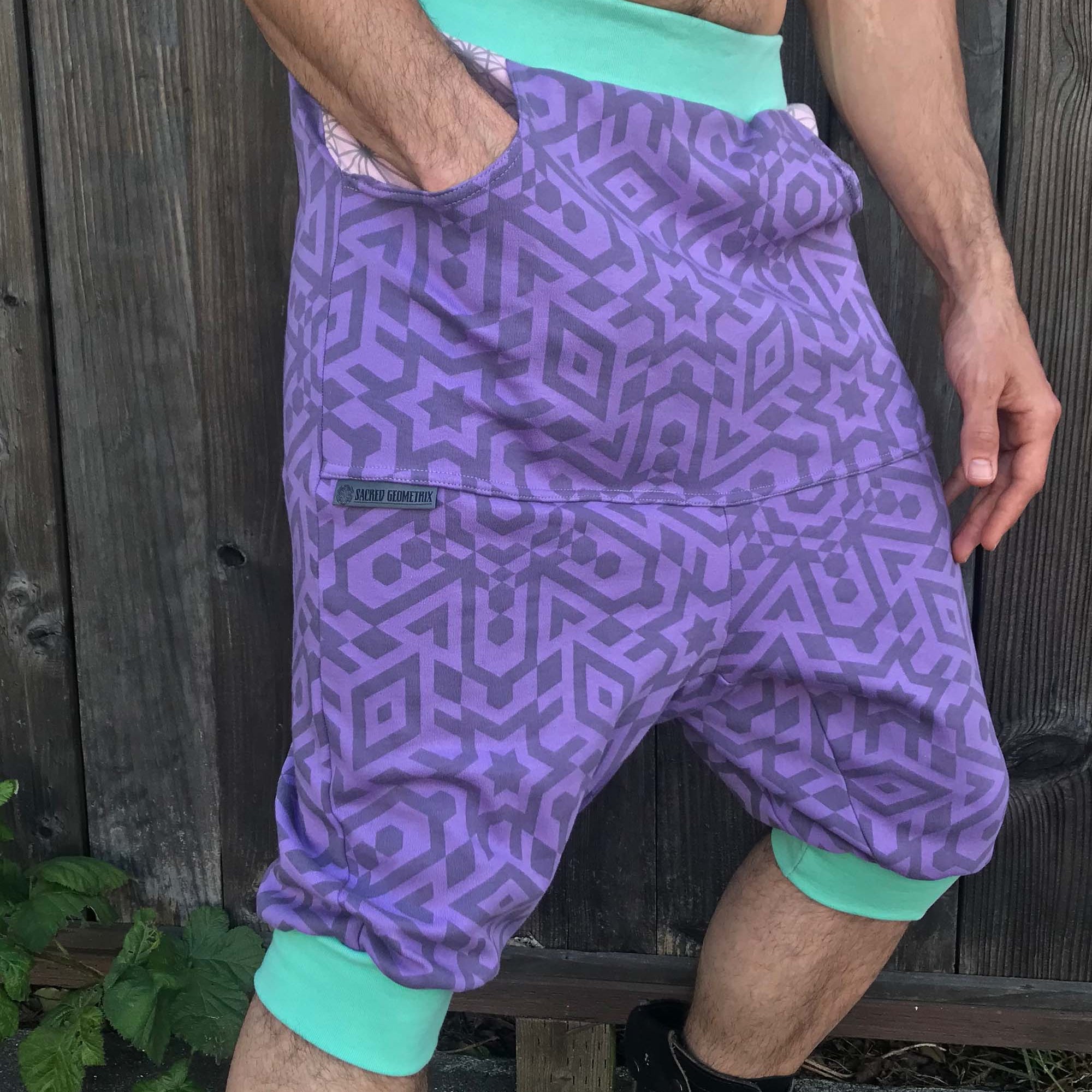 Organic cotton drop crotch shorts, lavender fabric with geometric print, front left side view on model.