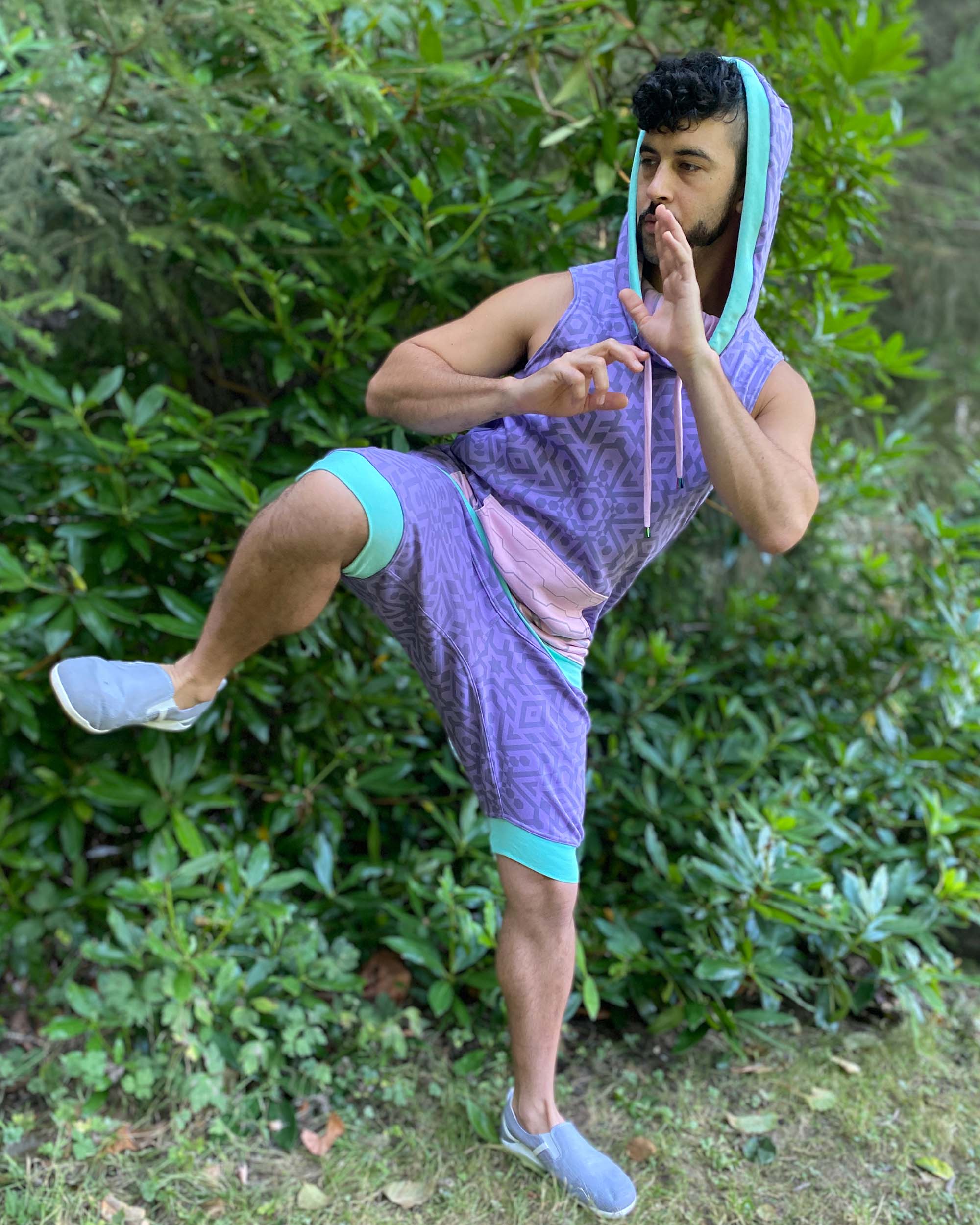 Organic cotton hooded tank top and matching shorts, lavender fabric with geometric print, side view on model.