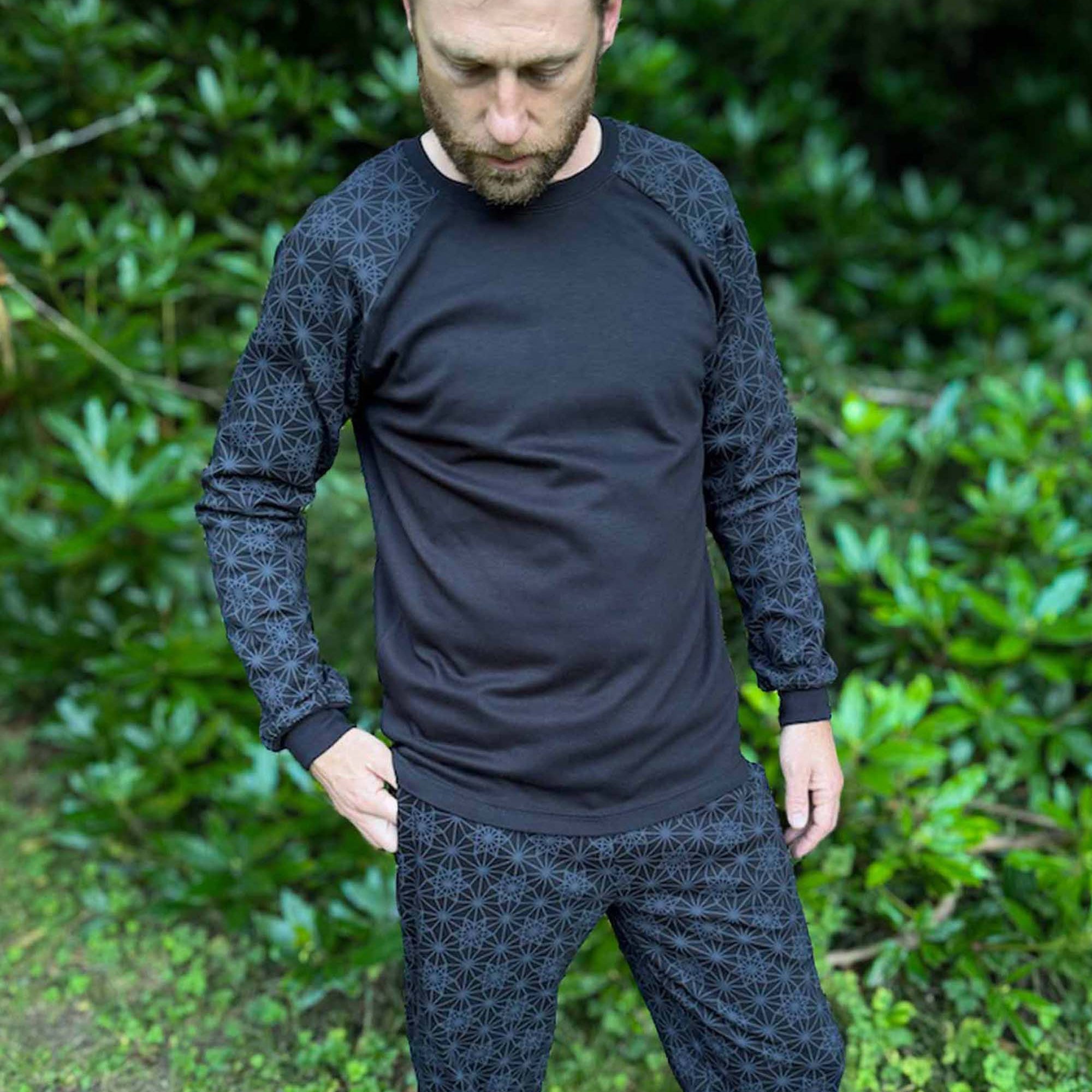 Organic cotton long sleeve shirt, black with vector equilibrium print, front view on male model.