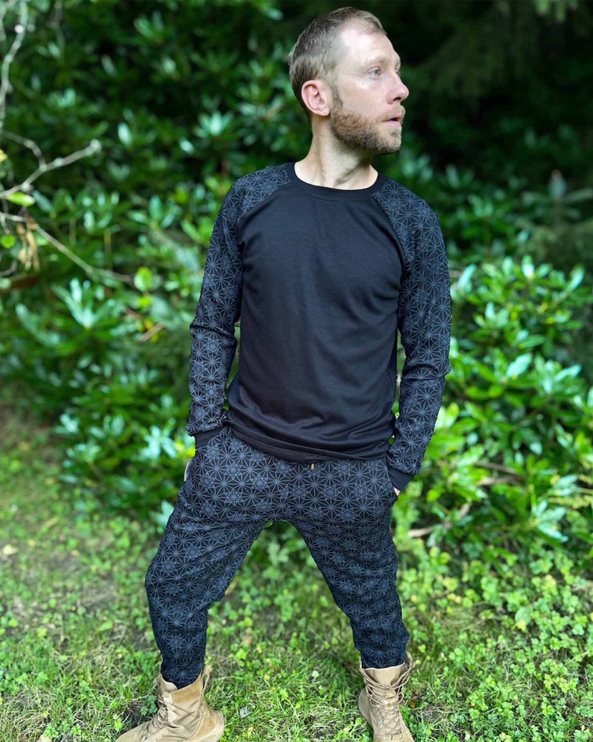 Organic cotton long sleeve shirt and matching pants, black with geometric sleeve prints, front view.
