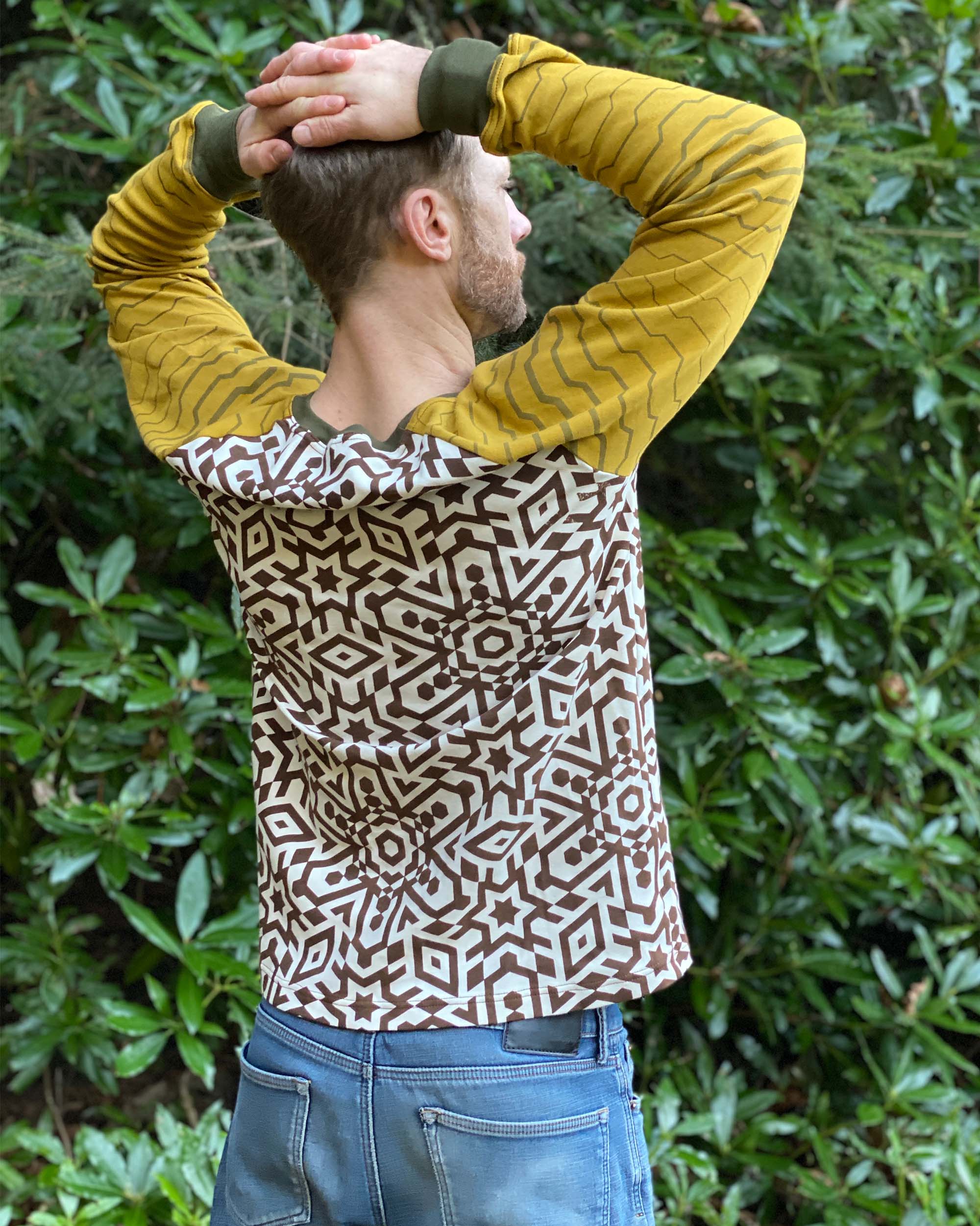 Organic cotton long sleeve shirt, undyed torso with yellow geometric striped sleeves, back view on model.